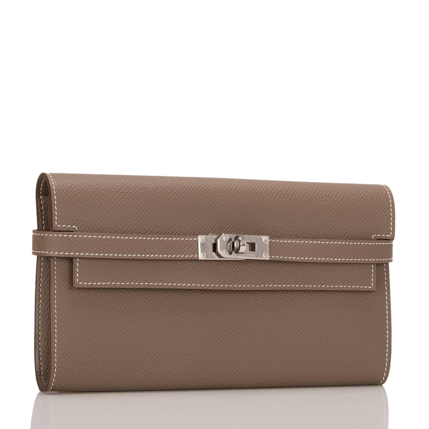  	
Hermes Etoupe Epsom leather Kelly Longue Wallet with palladium hardware.

This style features white contrast stitching, palladium hardware, two front straps and front toggle closure.

The interior is lined in Etoupe chevre leather and