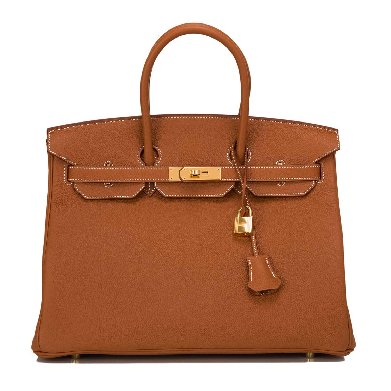 Hermes Gold Birkin 35cm of togo leather with gold hardware.

This Birkin has white contrast stitching, a front toggle closure, a clochette with lock and two keys, and double rolled handles.

The interior is lined with Gold chevre and has one zip