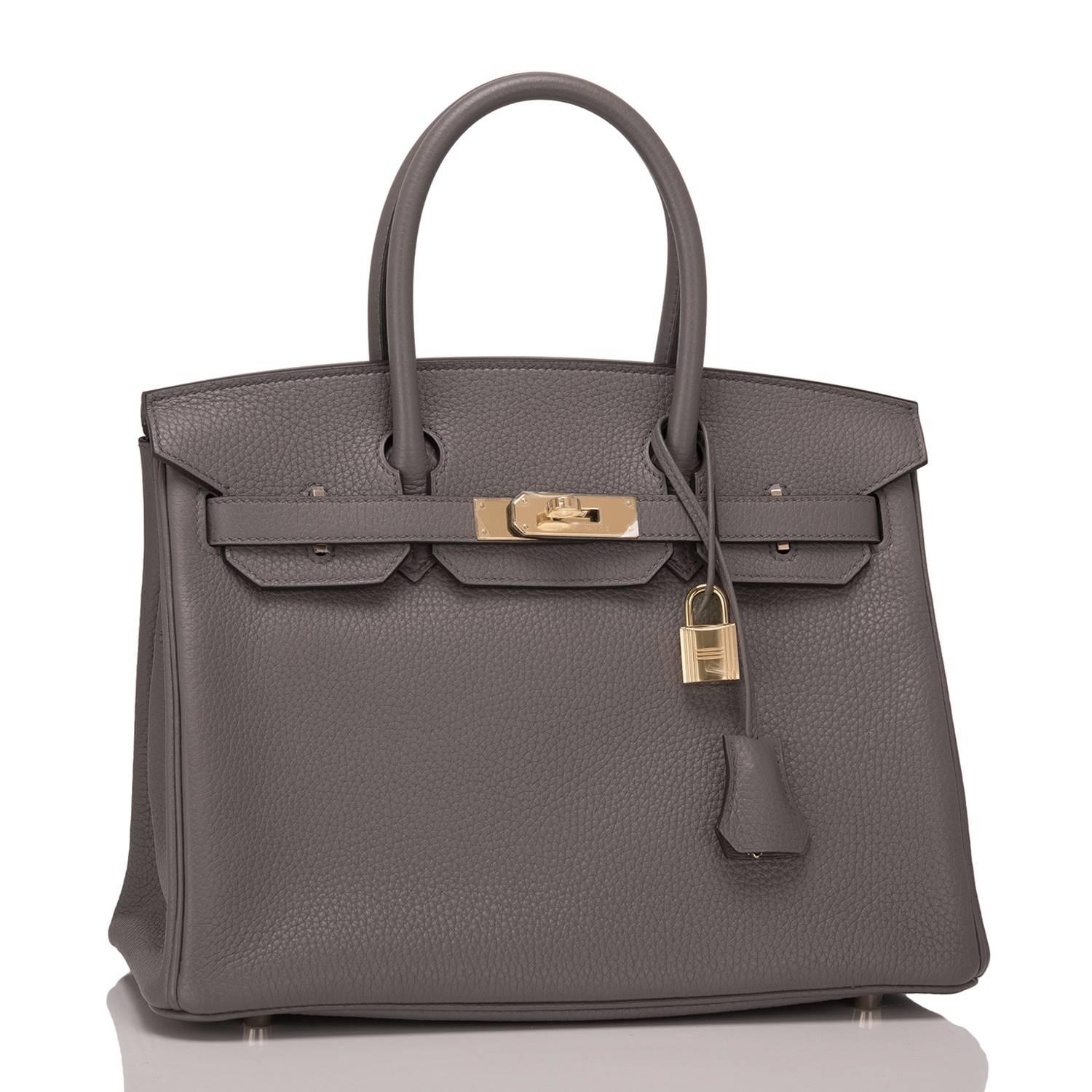 Hermes Etain 30cm of clemence leather with gold hardware.

This Birkin has tonal stitching, a front toggle closure, a clochette with lock and two keys, and double rolled handles.

The interior is lined with Etain chevre and has one zip pocket