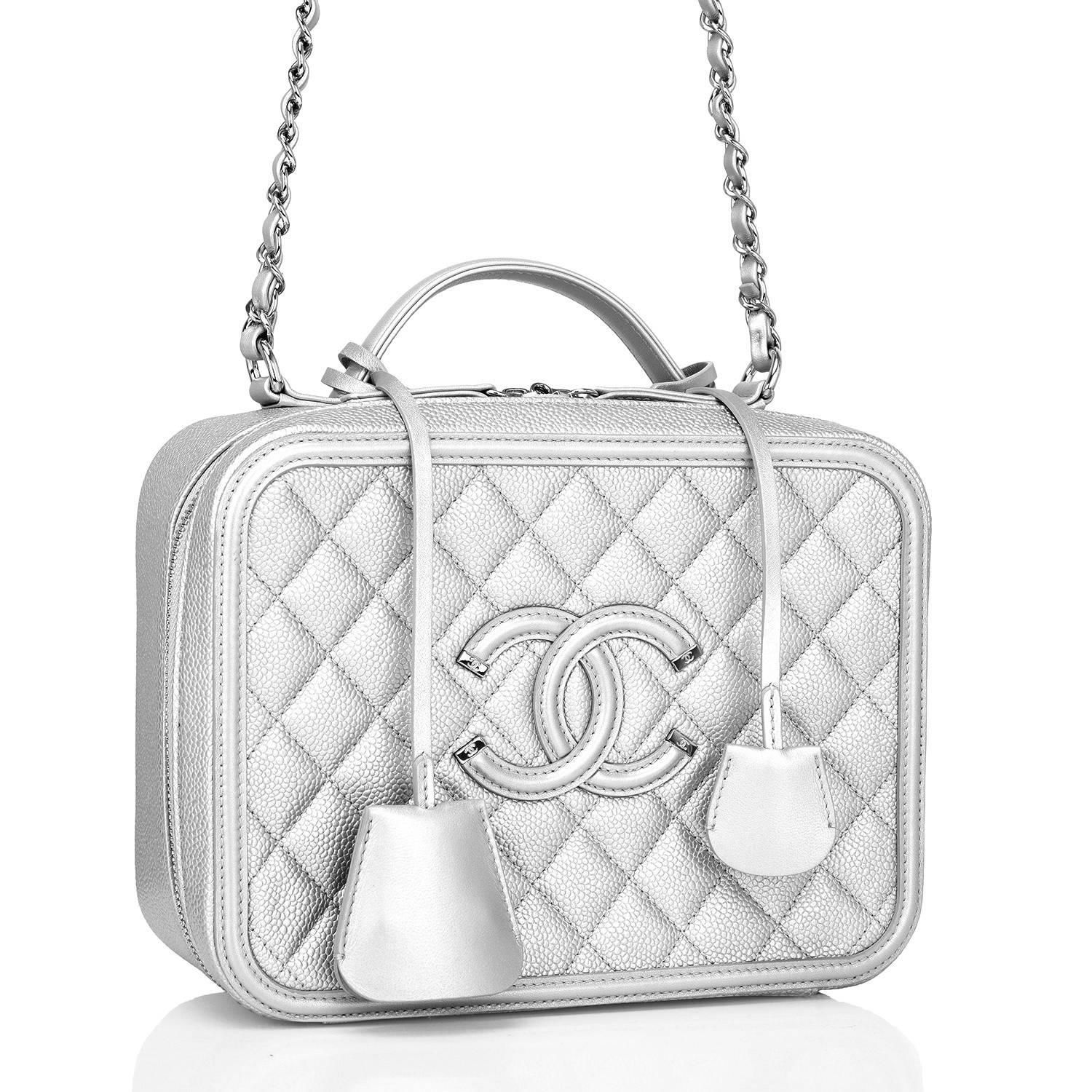 Chanel Medium Vanity Case of silver caviar leather with silver tone hardware.

This bag features Chanel's signature CC logo stitch in on the front, a silver tone CC lock with a clochette, a matching key with another clochette, zip around closure,