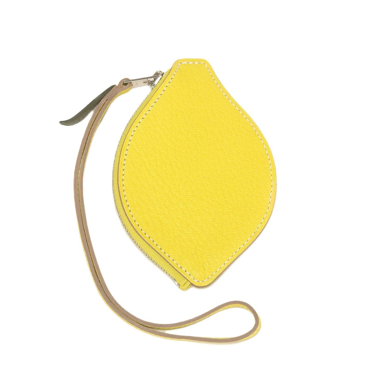 Hermes Lemon Tutti Frutti Porte Monnaie coin purse of yellow chevre leather and palladium- and silver- hardware.

This limited edition coin purse is shaped as a lemon and has tonal stitching, silver plated zipper closure and matching yellow strap so