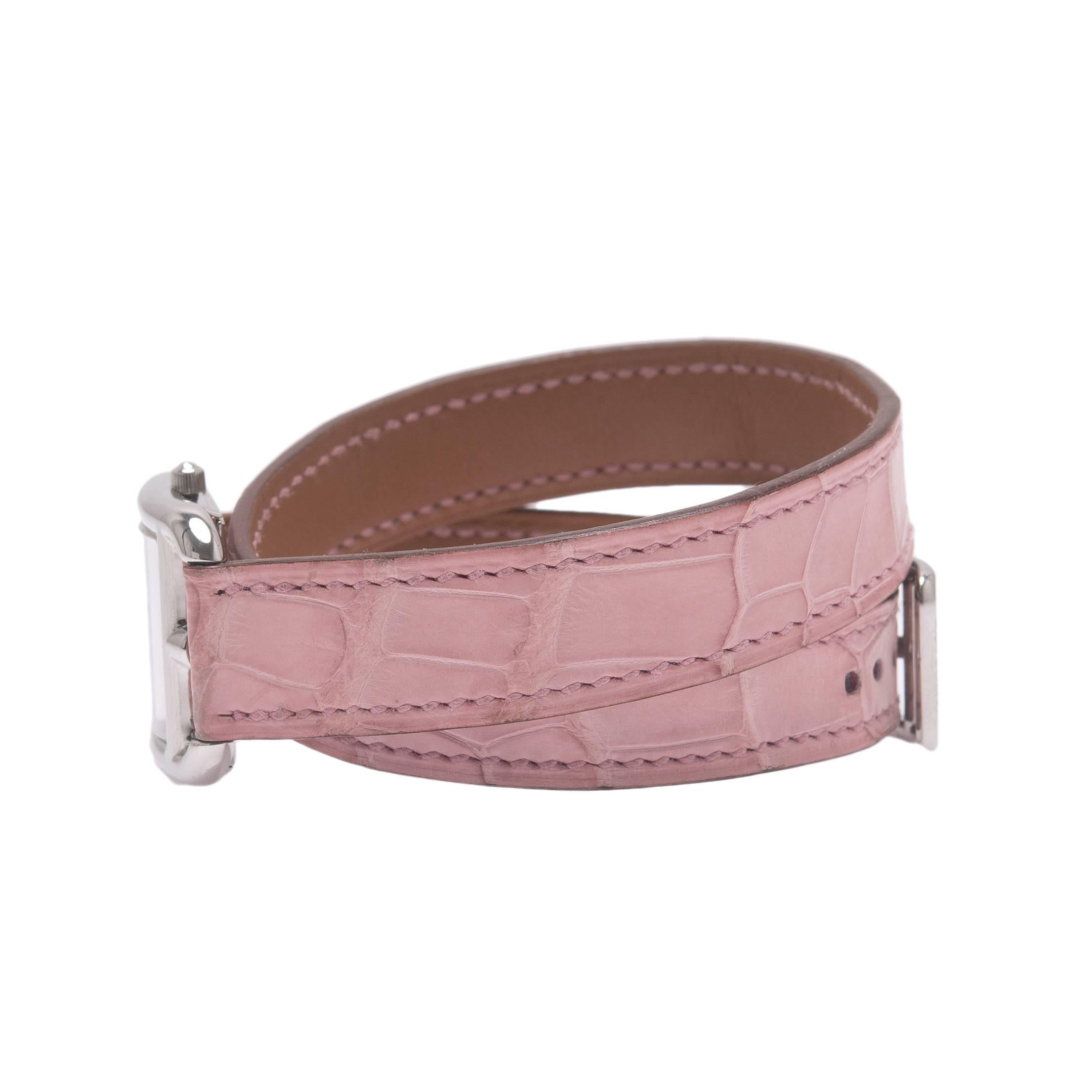 Hermes Cape Cod watch size PM with pink alligator double tour band.

This watch is made of stainless steel with an adjustable and interchangeable pink alligator double tour band.

The watch features a Swiss quartz movement, silvered dial, hour and