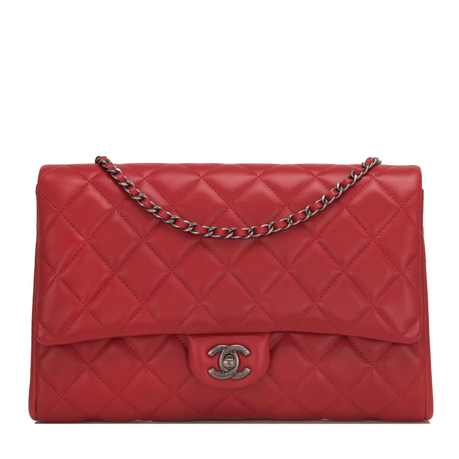 Chanel New Clutch With Chain of quilted red lambskin with ruthenium hardware.

This bag features CC turnlock closure, a rear envelope pocket, and interwoven ruthenium metal chain link with red leather shoulder strap which can be tucked in to be