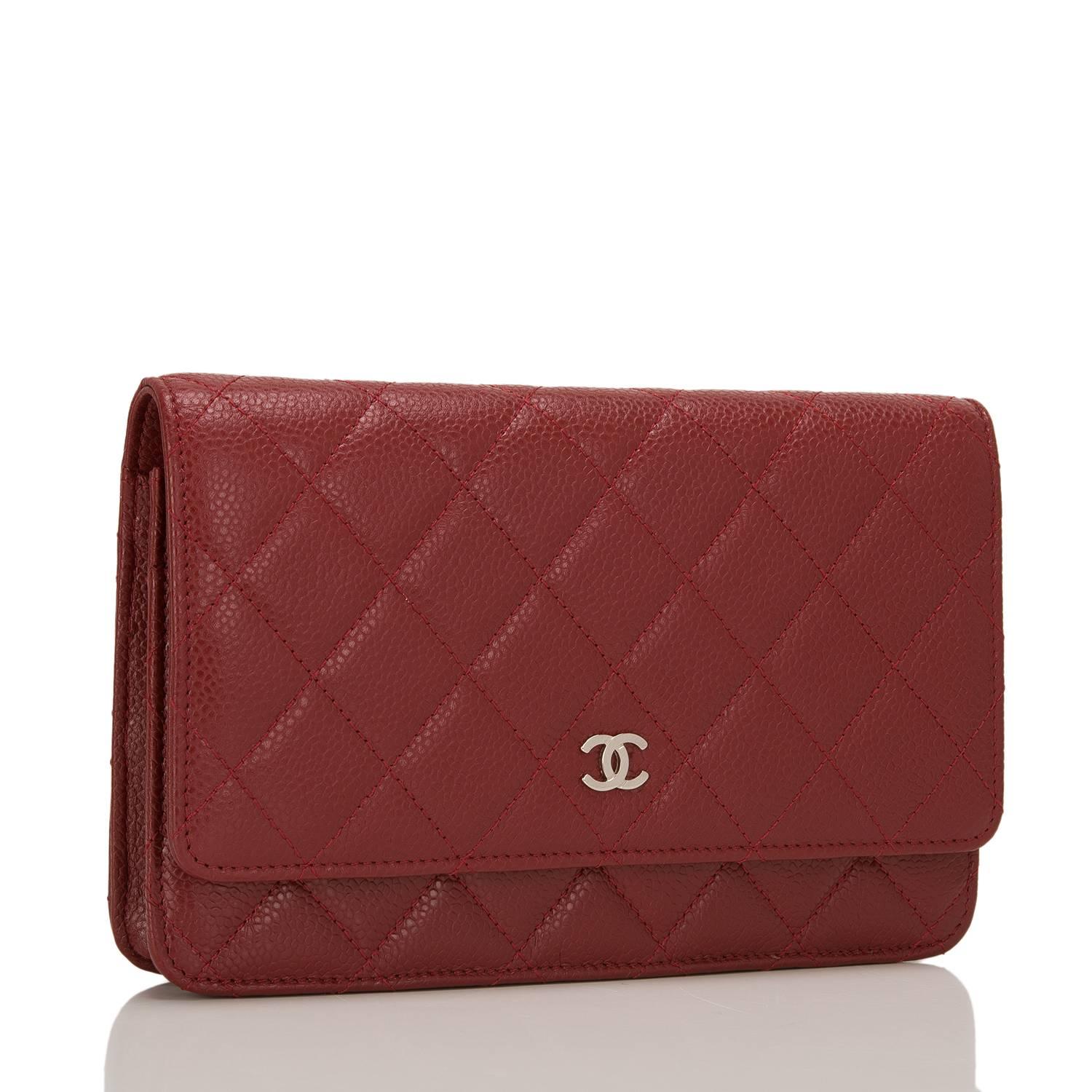This timeless Wallet on Chain (WOC) in dark red caviar leather with silver tone hardware features signature Chanel quilting, front flap with CC charm and hidden snap closure, expandable sides and bottom, half moon rear pocket and interwoven silver