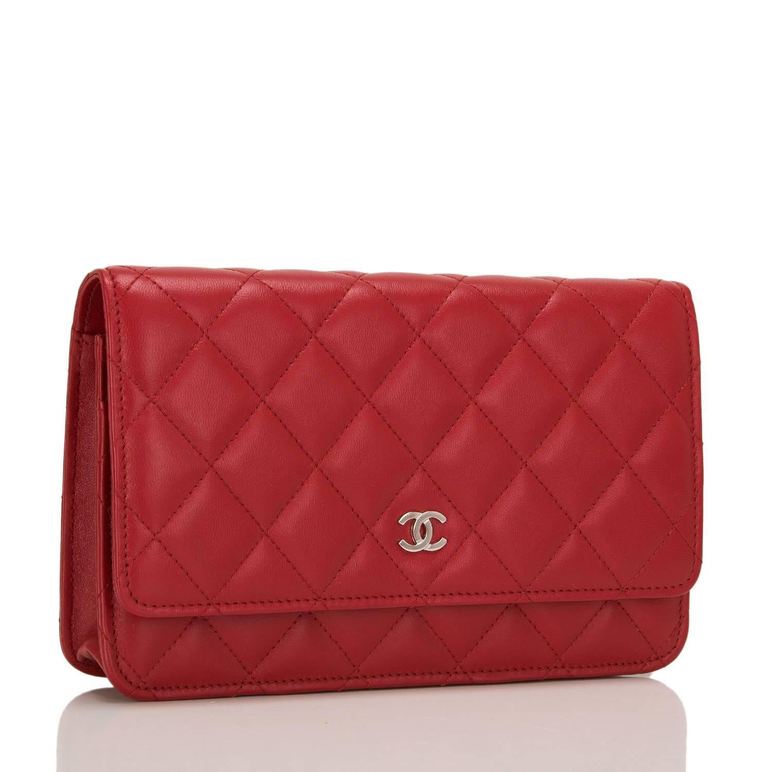 This timeless Wallet on Chain (WOC) in red lambskin leather with silver tone hardware features signature Chanel quilting, front flap with CC charm and hidden snap closure, expandable sides and bottom, half moon rear pocket and interwoven silver tone