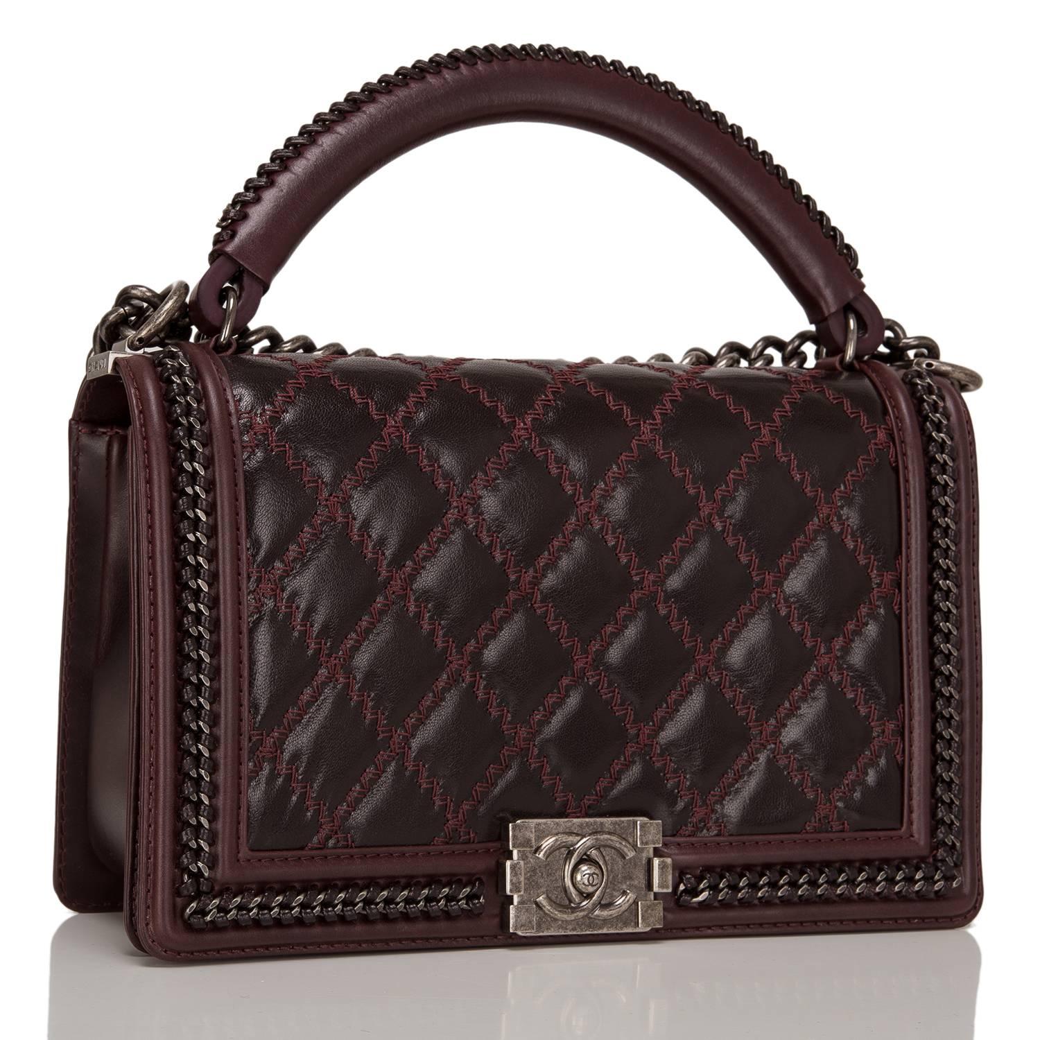  	
This Chanel limited edition New Medium Boy bag with a top handle is made of shiny goatskin leather and accented with aged ruthenium hardware.

The bag features a limited edition braided leather and chain top handle, a full front flap with the