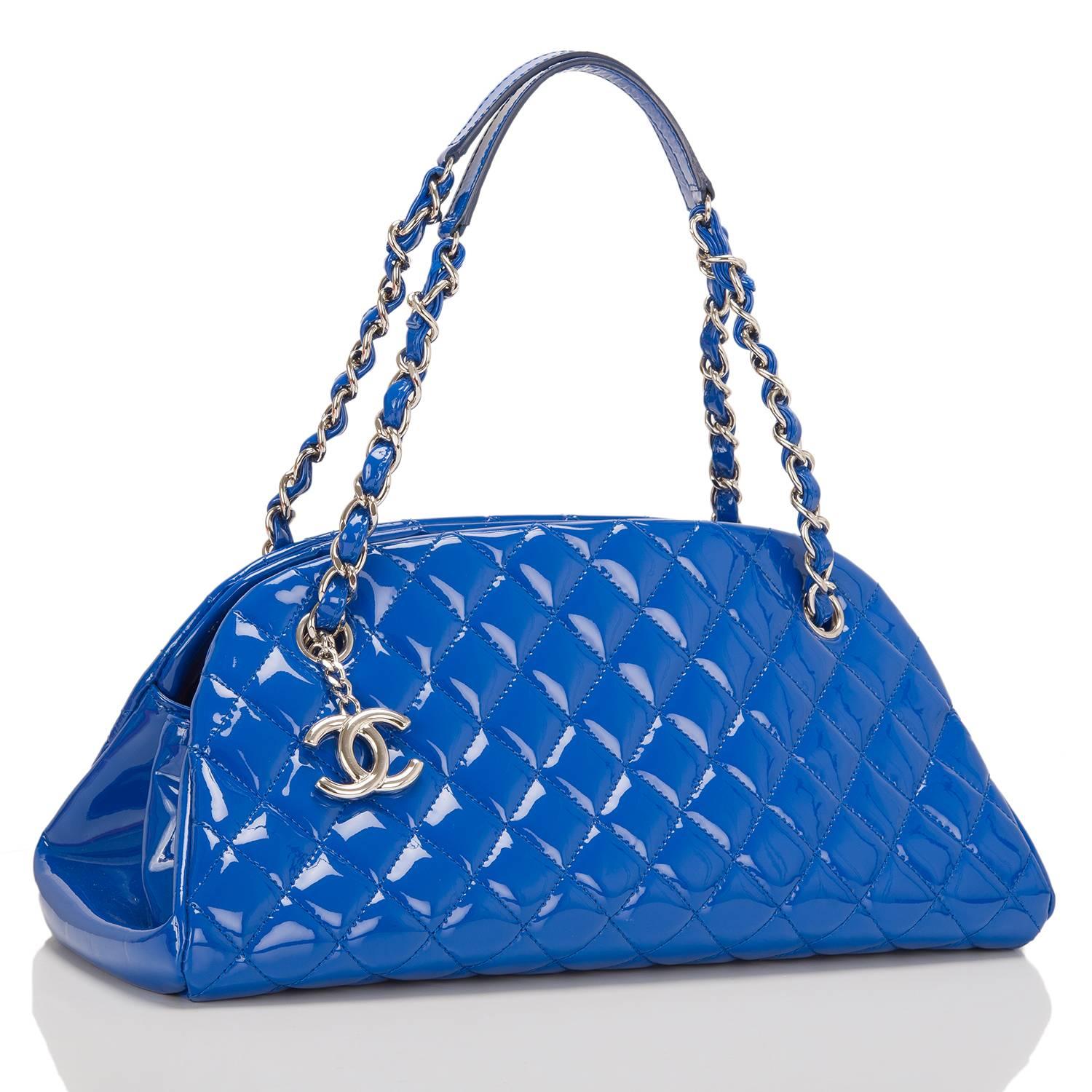 This Chanel Just Mademoiselle bag is made of bright blue patent leather and accented with silver tone hardware.

The bag features a front dangling signature CC charm, an open top closure and interwoven silver tone chain link and blue leather