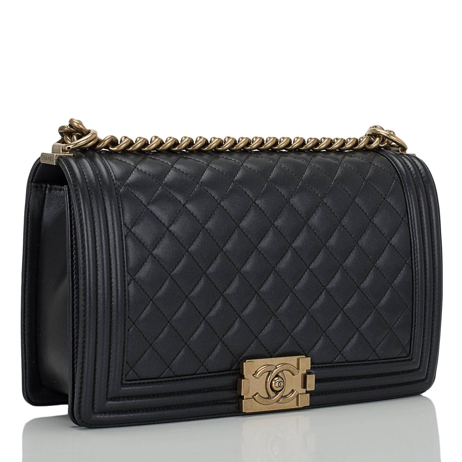 This Chanel Large Boy bag is made of lightly pearlized black lambskin leather and accented with antique gold tone hardware.

The bag features quilted leather trims in smooth calfskin, a full front flap with the Boy signature CC push lock closure,