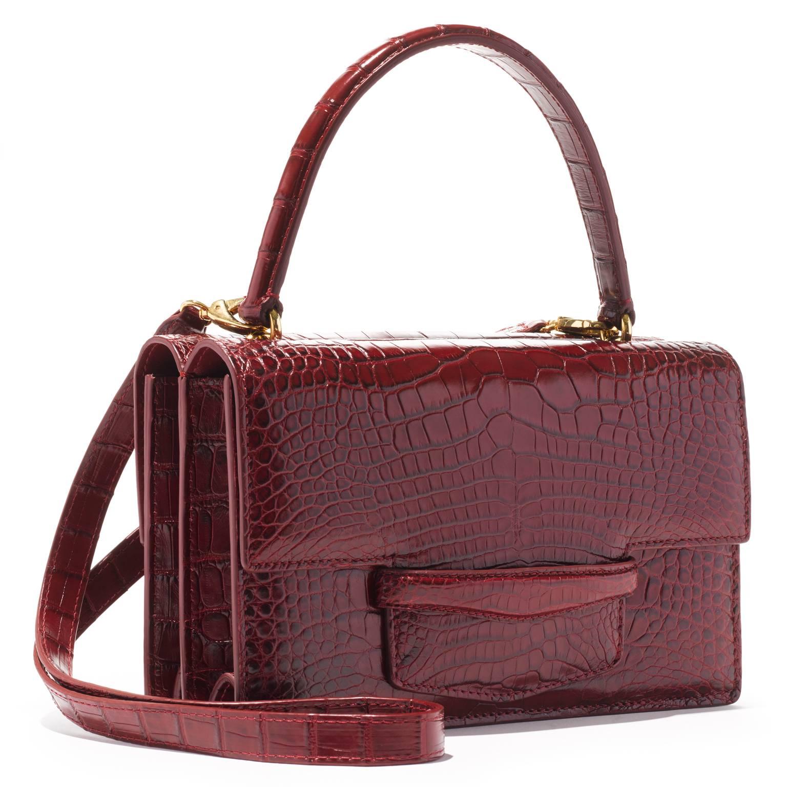 This double gusseted alligator bag is fully lined in leather. A stitched doubled sided handle is joined to the bag with interlocking gold rings. There is an additional 40” detachable shoulder strap. 

- one exterior pocket in center of the bag 
-
