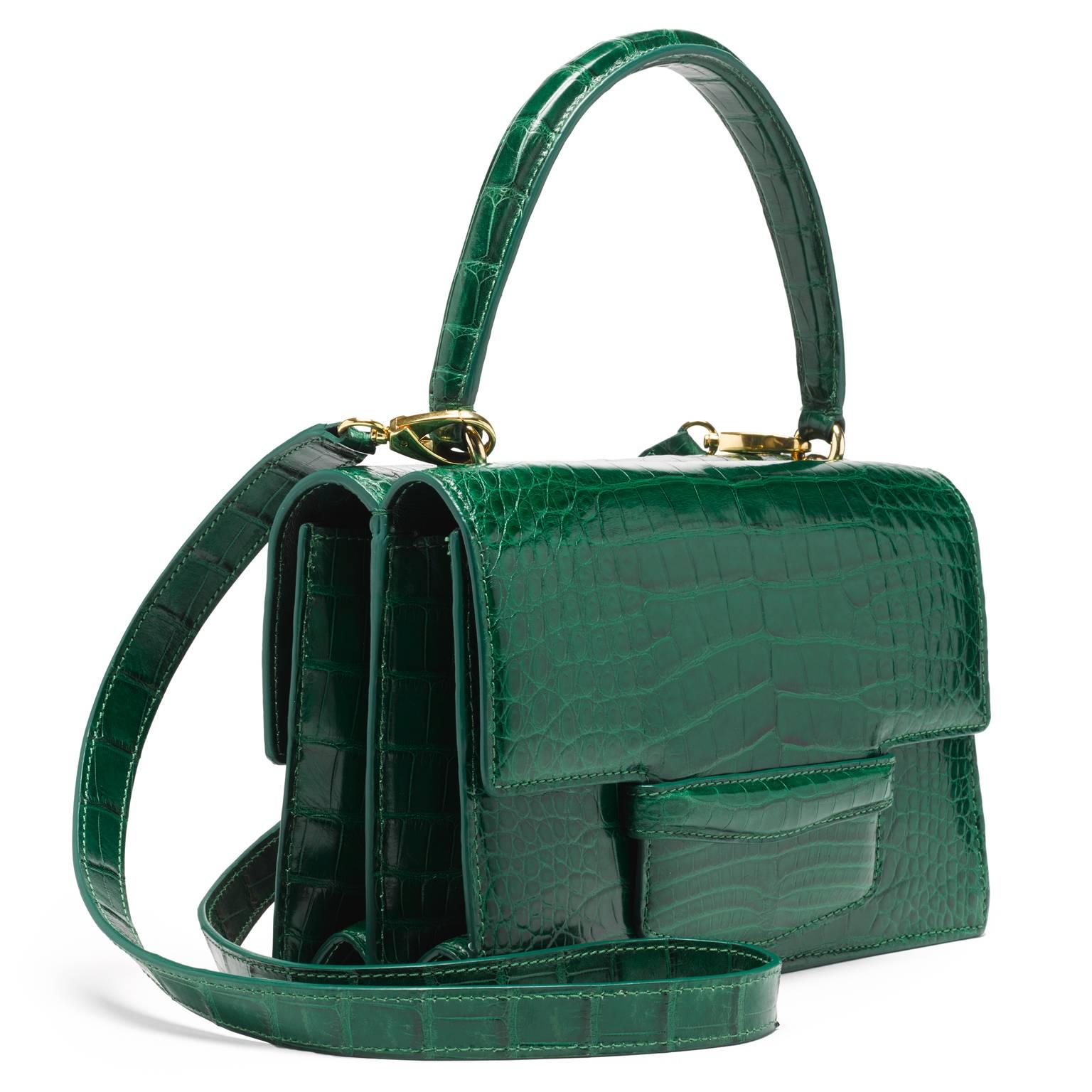 This double gusseted alligator bag is fully lined in leather. A stitched doubled sided handle is joined to the bag with interlocking gold rings. There is an additional 40” detachable shoulder strap. 

- one exterior pocket in center of the bag 
-
