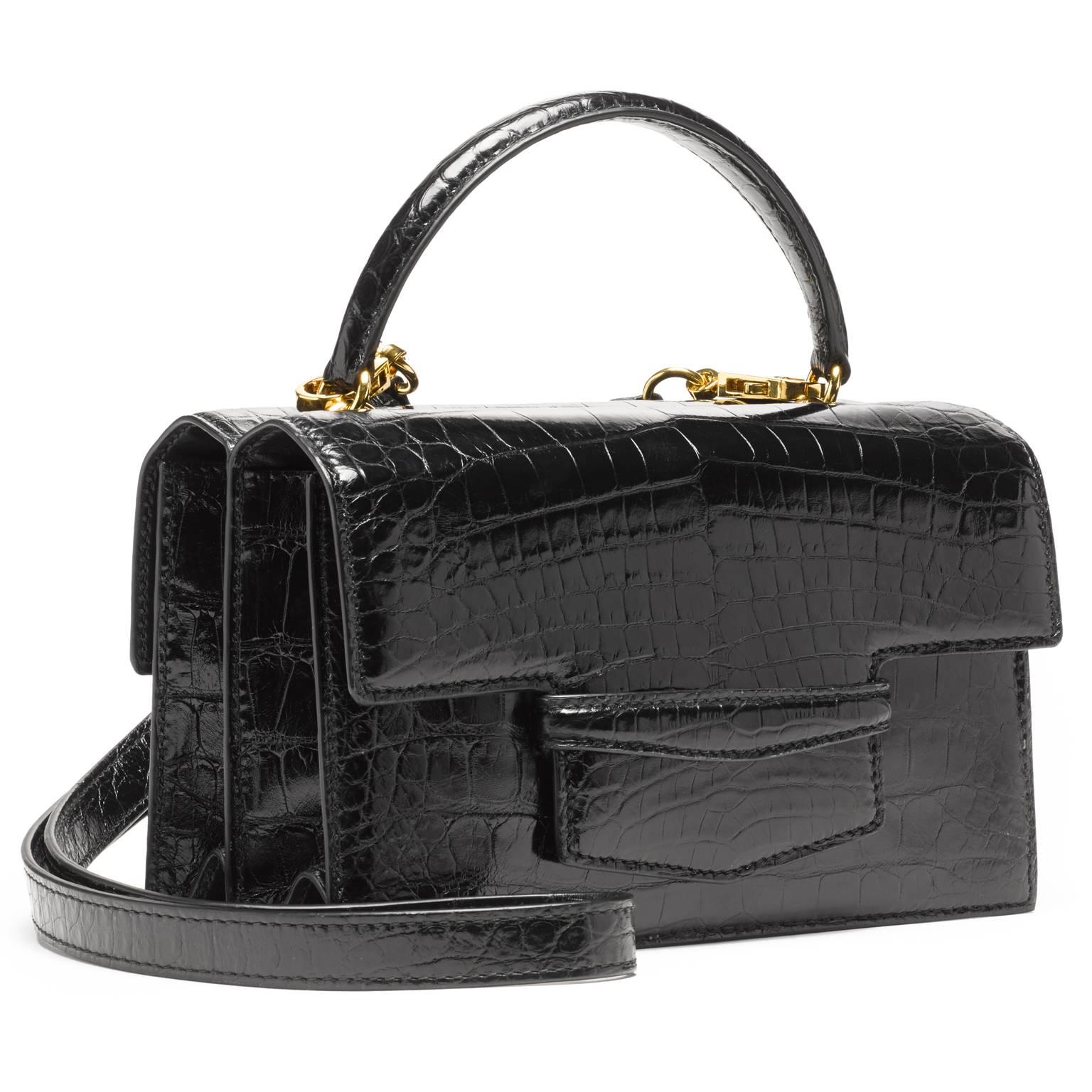 This double gusseted alligator bag is fully lined in leather. A stitched double-sided handle is joined to the bag with two interlocking gold rings. There is an additional 38” detachable shoulder strap.

- one exterior pocket in center of the bag