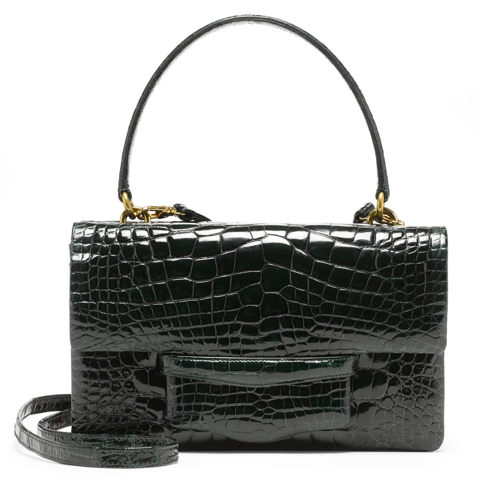 This double gusseted alligator bag is fully lined in leather. A stitched doubled sided handle is joined to the bag with interlocking gold rings. There is an additional 52” detachable shoulder strap.  

- one exterior pocket in center of the bag 