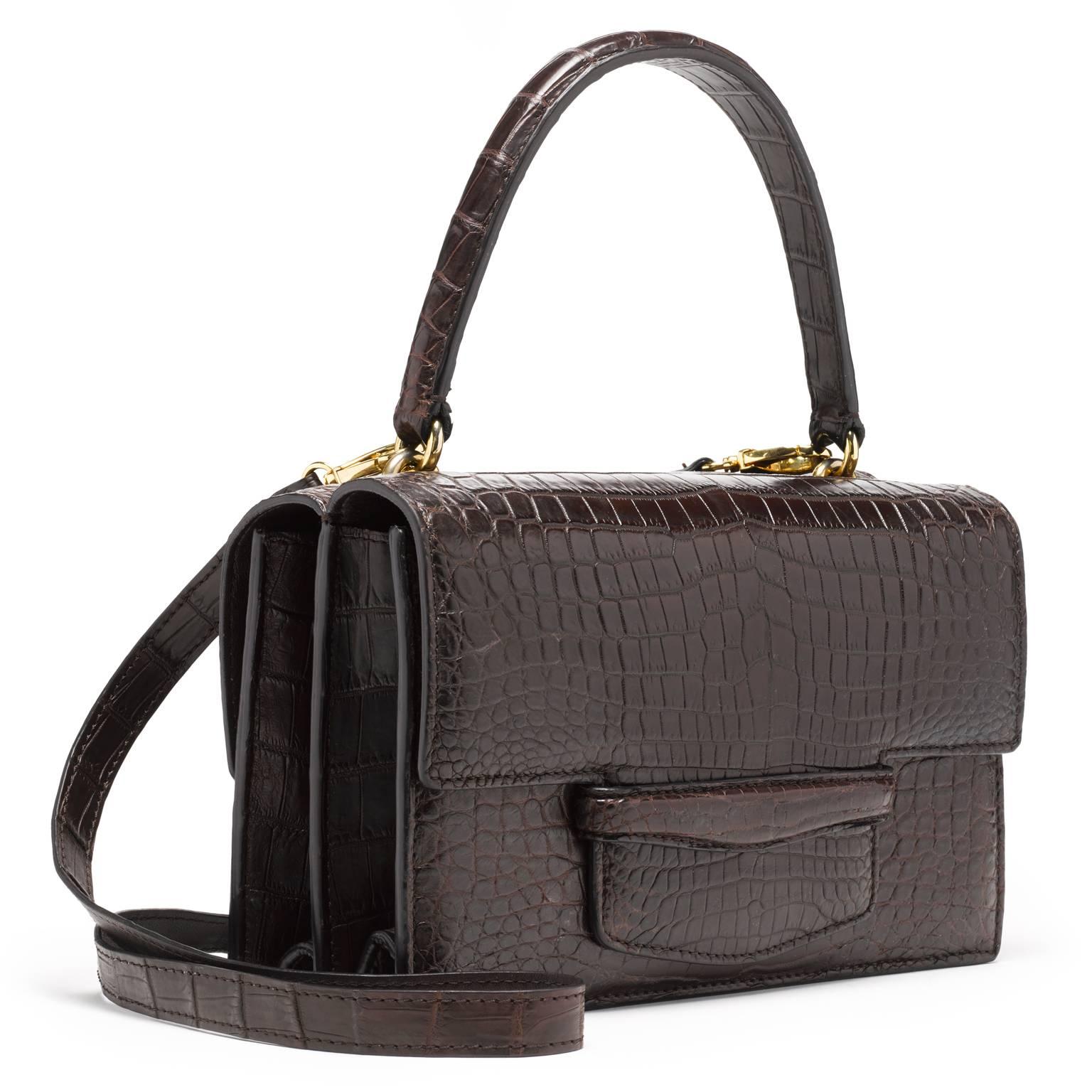 This double gusseted crocodile bag is fully lined in leather. A stitched double-sided handle is joined to the bag with two interlocking gold rings. There is an additional 40” detachable shoulder strap.

- one exterior pocket in center of the bag