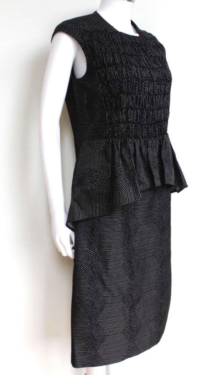 Dries Van Noten Charcoal Peplum Jacquard Dress 40 uk 12
Ruched bodice, with pleated peplum detail
Concealed hook fastening to the back 
55% cotton, 21% wool, 21% polyester 3% acatate
Fitted at the bust and waist, loose at the hip. Mid-weight,