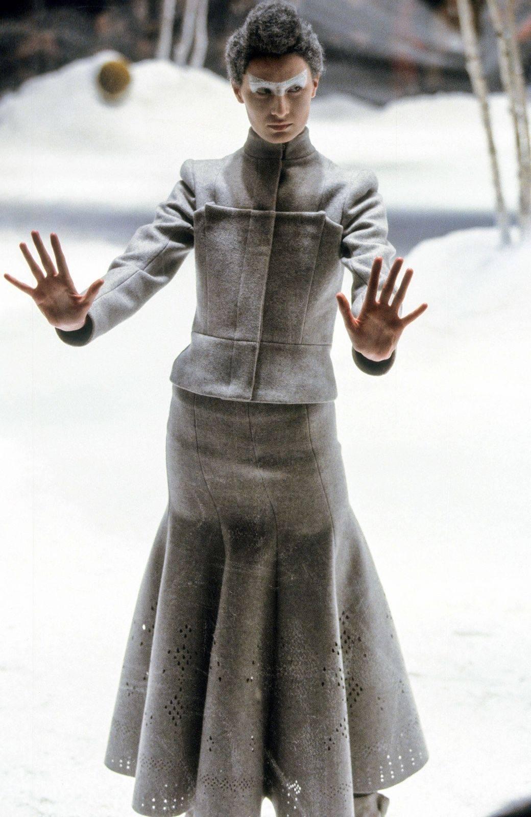 Alexander McQueen Vintage 1999 Grey Coat It 42 Uk 10
Rare piece from the fall 1999 collection 
Grey with slight metallic finish 
Pleated detail to the front 
Fully lined, with concealed button fastening
Length 38 inches, sleeve 23 inches, chest 19