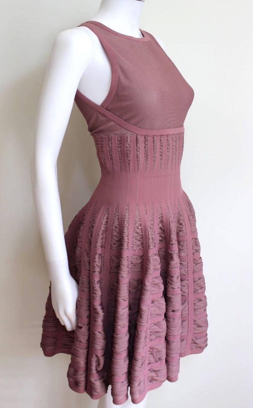 ALAIA Mauve Ribbed Flounce Dress 38 uk 8-10 
Beautiful stretch dress from Alaia with pleated full skirt 
Dark pink light purple colour, concealed zip 
The chest and back is slightly sheer, could benefit from a slip underneath 
Length 35.5 inches.