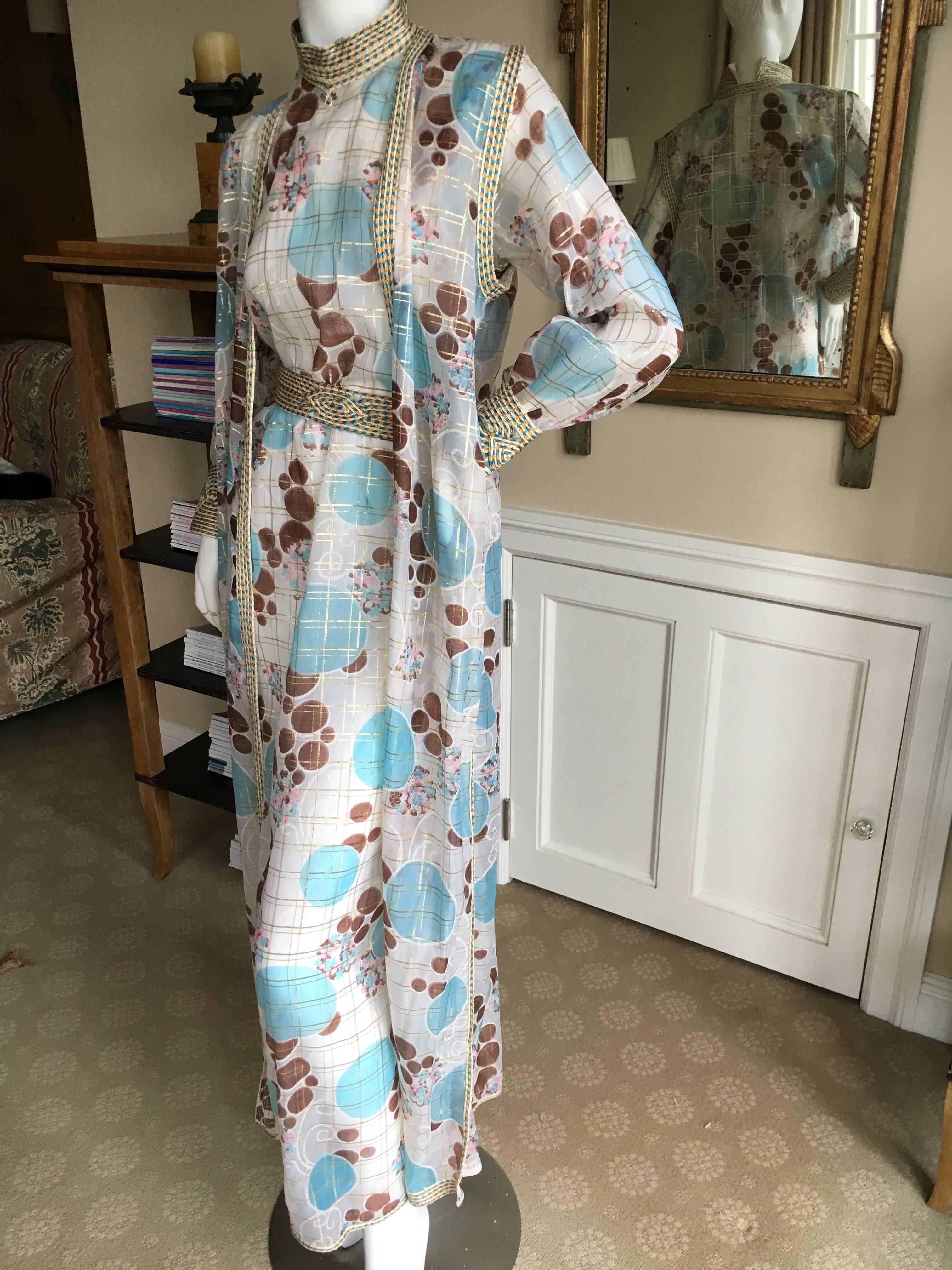 Wonderful sheer three piece evening dress / caftan from Adolfo circa 1977.
There is a dress, sleeveless vest and matching belt.
Bust 38"
Waist 42"
Hips 44"
Length 57"
Excellent condition