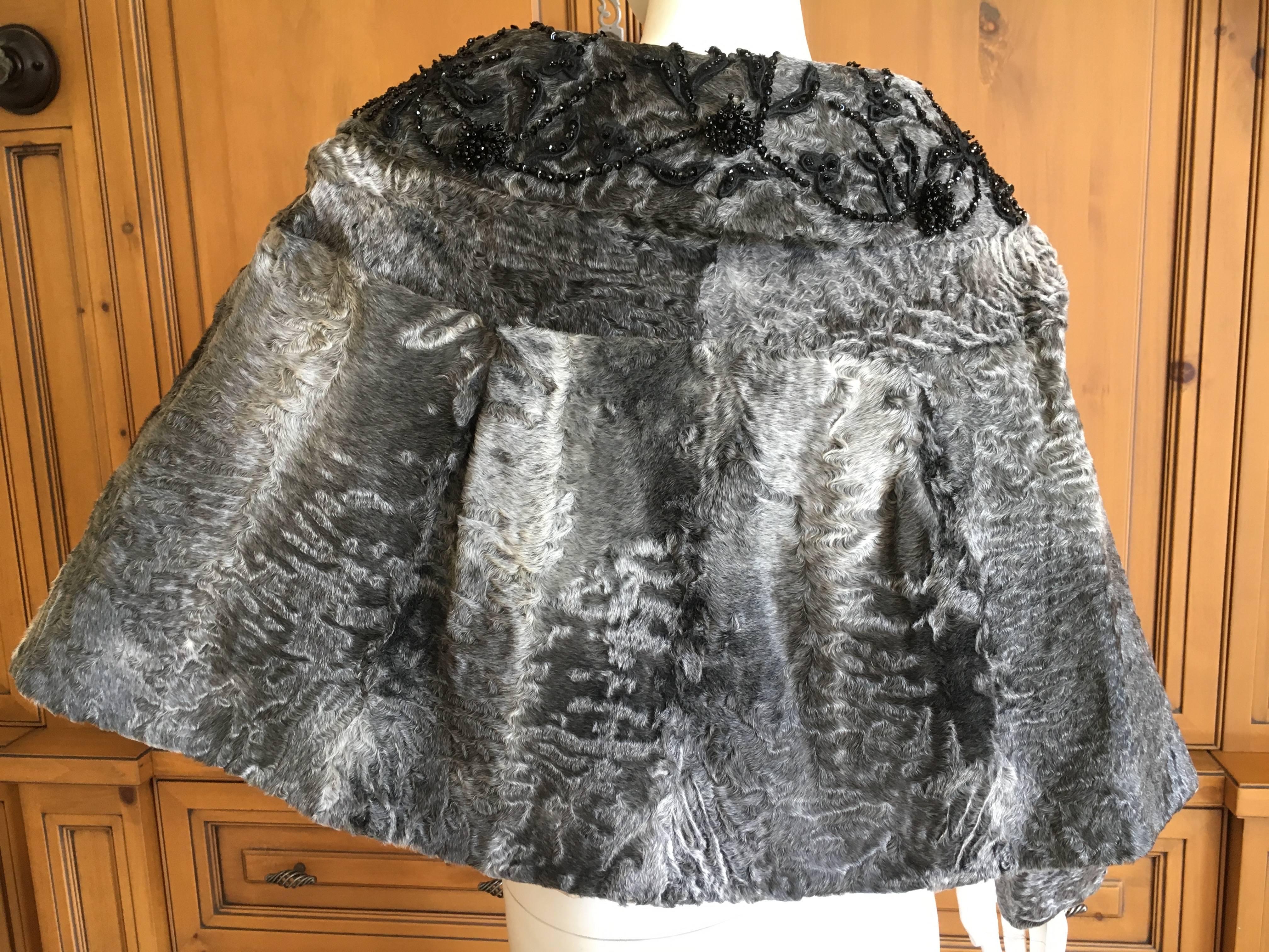 Prada Gray Broadtail Cape with Jet Bead Embellished Collar.
This has sleeve's inside, but can be worn as a caplet ore a jacket/cape.
Small