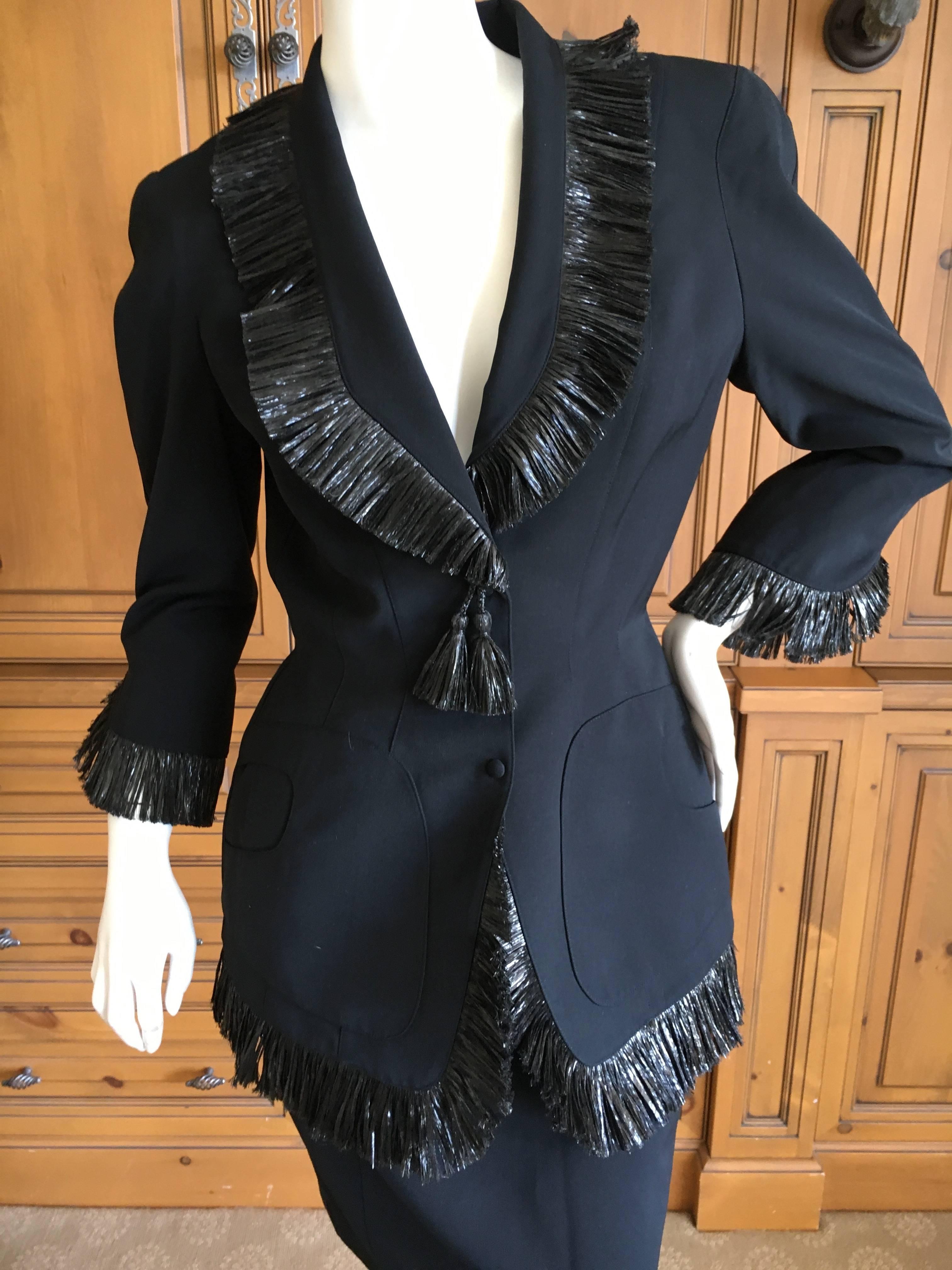 Thierry Mugler Vintage 1980's Black Suit with Raffia Fringe Tassel and Trim .
Classic Mugler from the eighties. 
Featuring a jacket and skirt.
Size 38
Jacket 
Bust 38"
Was it 28"
Length 28"
Skirt
Was it 26"
Hips 34"
Length