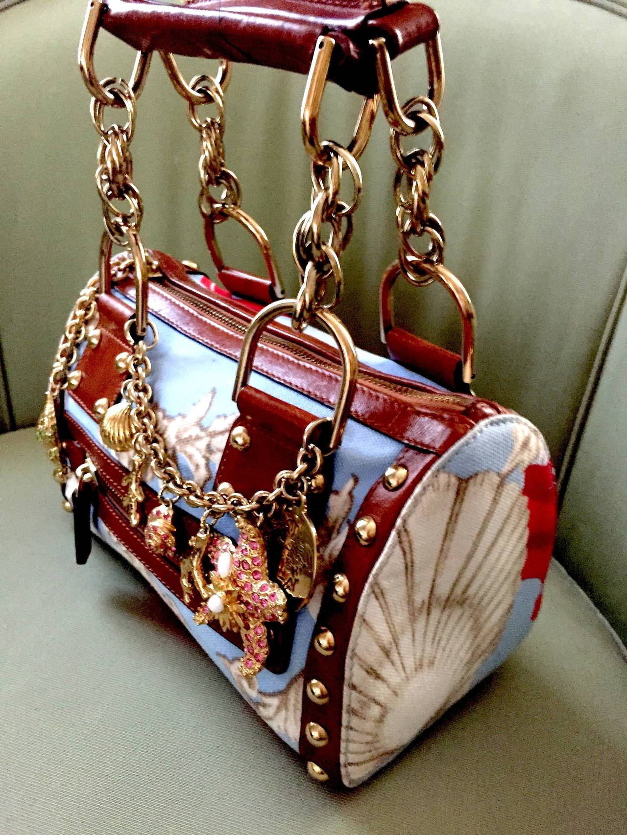 Wonderful vintage small handbag from Versace.
Spring 1992.
With a Baroque sea shell motif, trimmed in studded leather and festooned with dangling sea shell charms, this is a charming vintage Versace bag.

This is such a gorgeous bag, so great,