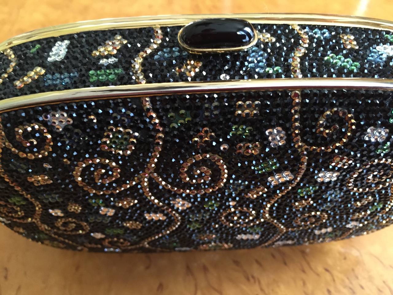 Judith Leiber Vintage Minaudiere.
Jet crystal background set with gold crystal scroll motif and jewel tone crystals.
Comes with comb change purse and mirror.