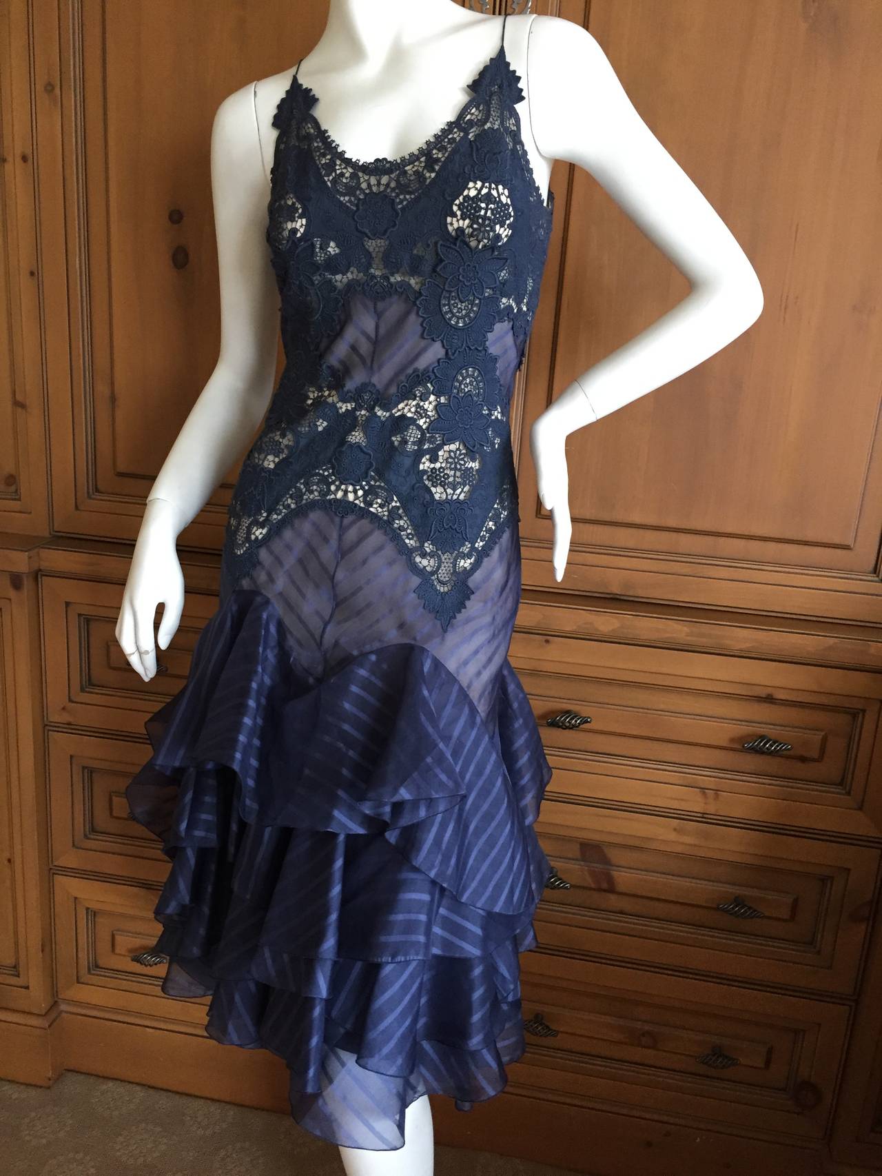 Alexander McQueen Sheer Navy Lace Dress 2004 .
Size 40
Exquisite Guipure Lace dress with ruffle flounces along the skirt.
It is lined with nude lining, so very pretty.
Bust 38