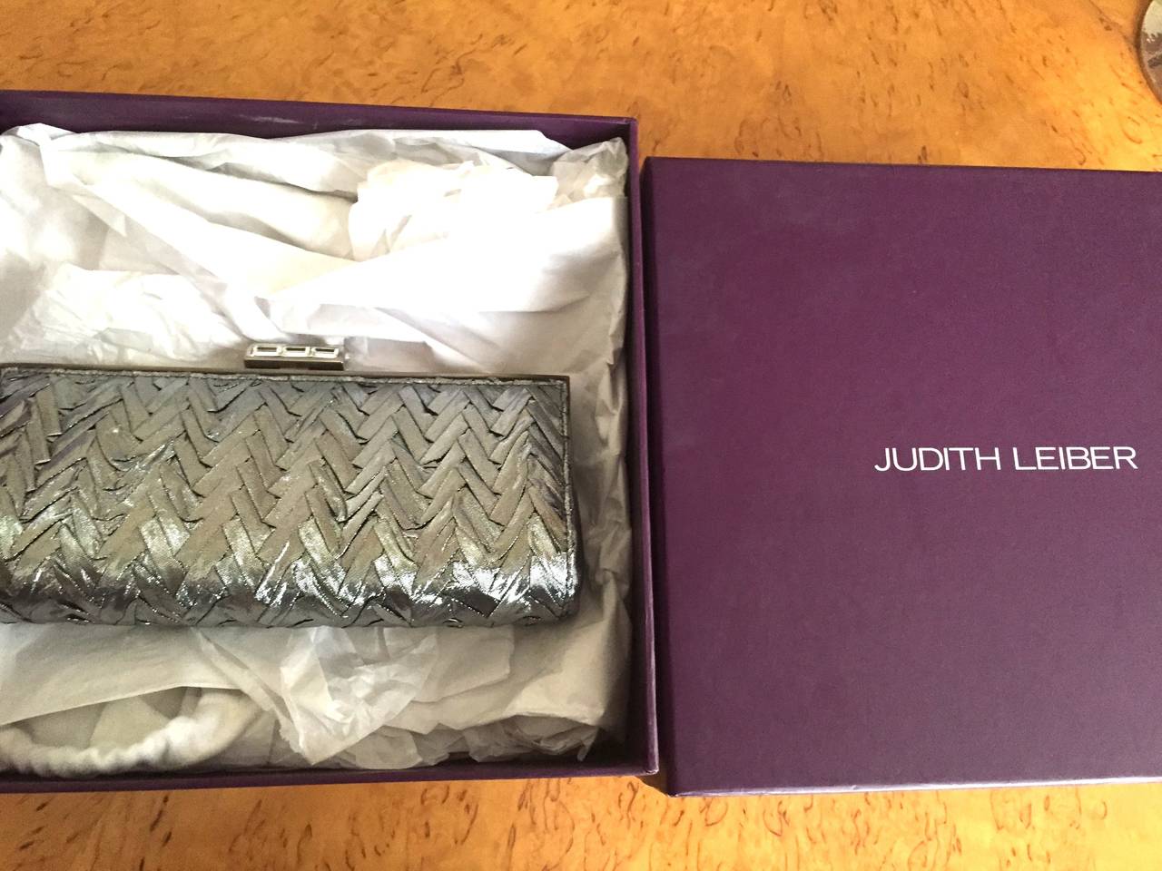 Judith Leiber Herringbone Silver Silk Clutch
New in box, there is a chain, hidden inside.