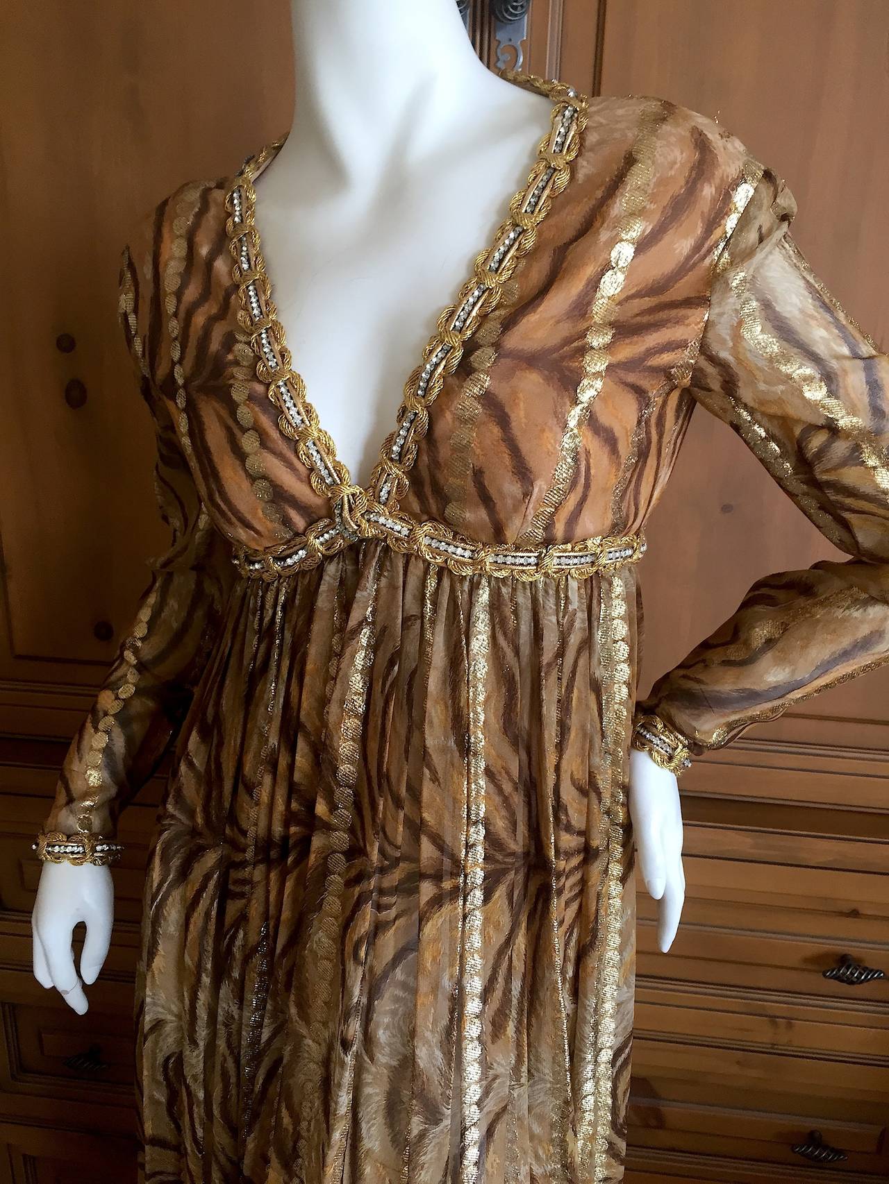 Bill Blass Seductive Vintage Empire Jeweled Silk Dress .
Stunning silk chiffon tiger print with gold accents, with Swarovski crystal and god wire work details.
Empire waist with a low cut bust trimmed in gold an crystal.
Measurements to follow