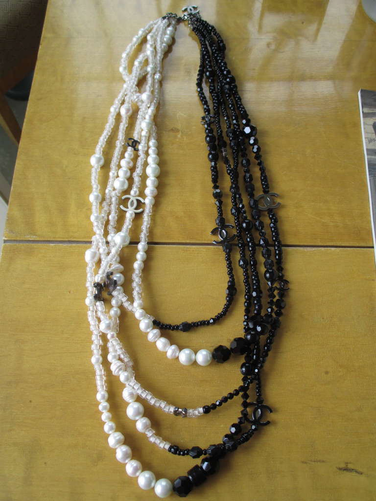 Chanel Black and White Multi Strand CC Necklace.
Spring 2005
Gunmetal finish.
Pearls and clear glass crystal beads on one side, with glass jet beads on the other.
 Shortest strand is 26