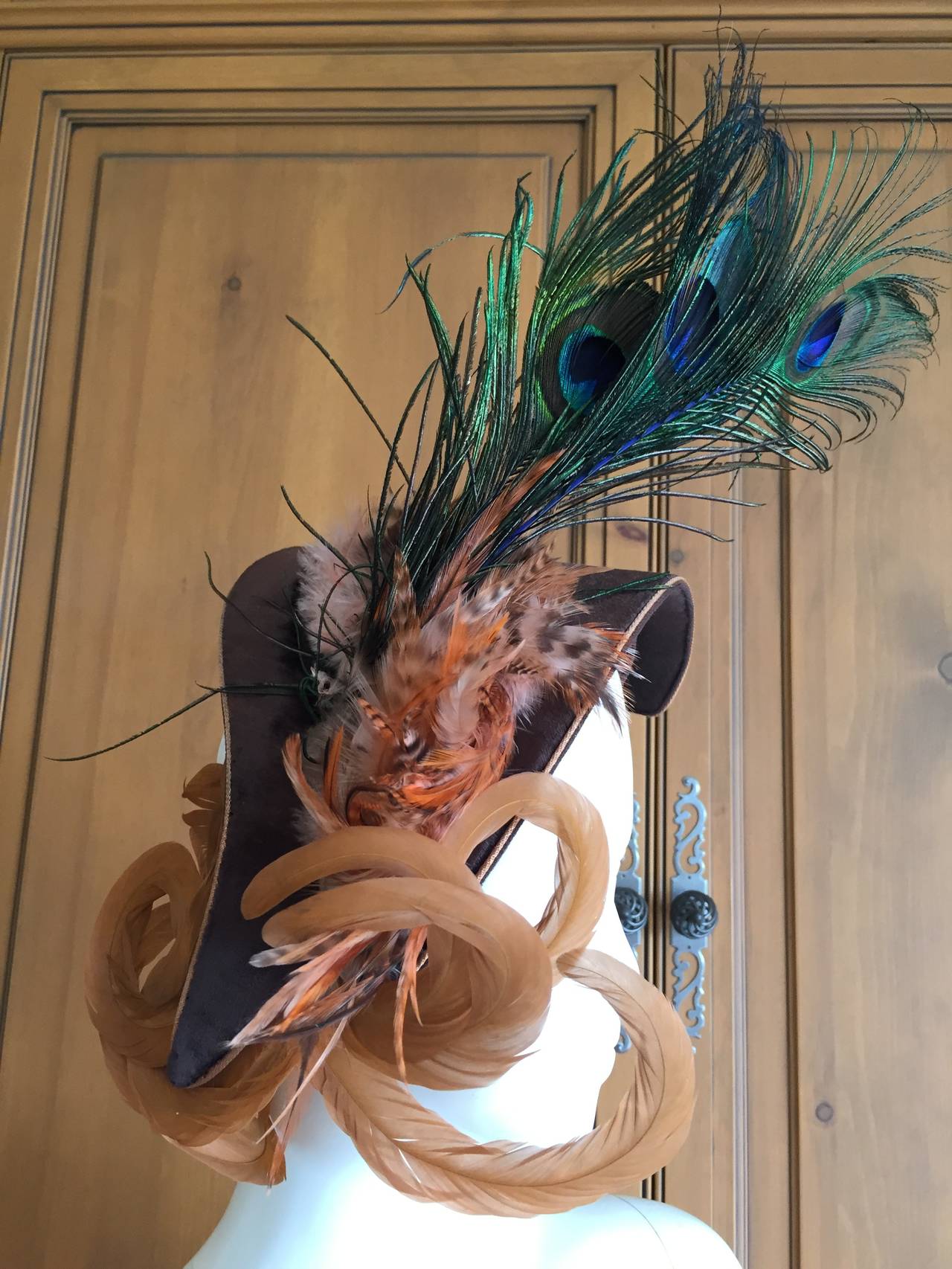 Wonderful vintage adorned with unusual feathers. Featuring Peacock and Bird of Paradise Feathers.
The small hat swoops down , very provocative and alluring, and is festooned with feathers. The top feathers are peacock, but I'm not familiar with the