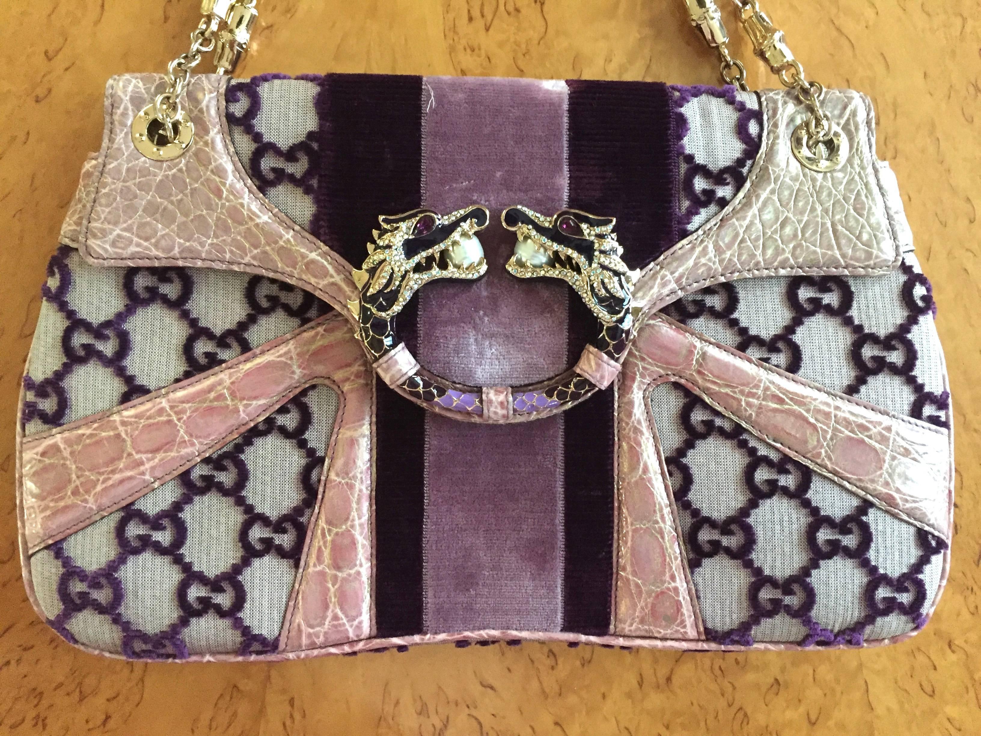 Gucci by Tom Ford Crocodile Dragon Bag
2002
This is an authentic GUCCI Monogram Tom Ford Crocodile Jeweled Dragon Flap Bag in Purple. This chic tote is finely crafted of a unique purple velvet GG monogram on canvas. There is a web detailing of two