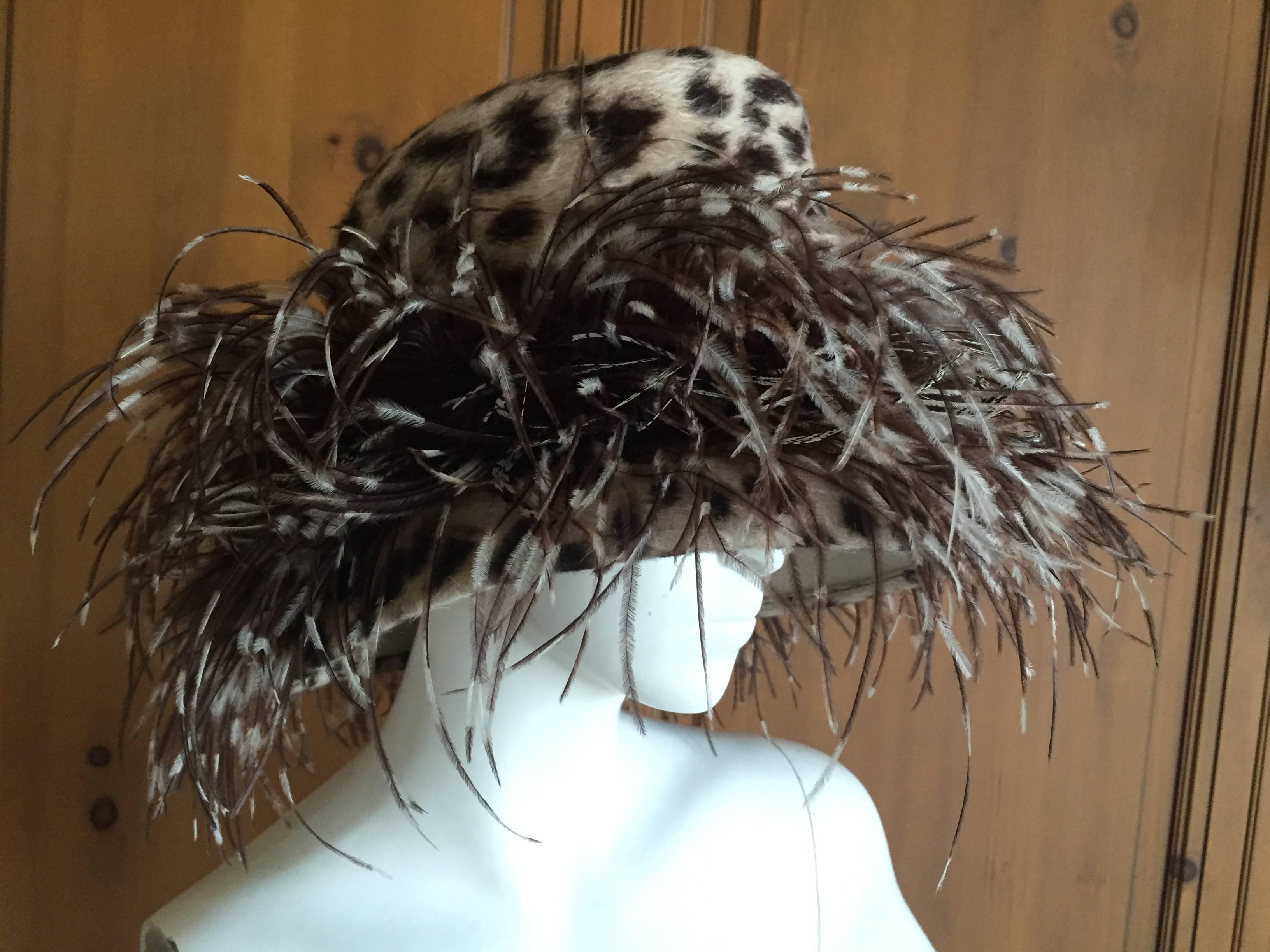 Wonderful feathered hat from Phillip Treacy London.
Featuring a gray and white faux leopard pattern hat , embellished with black white and gray feathers.
This is a large size. 
It fits my head and I wear a mens size  7 1/8.
22 1/2