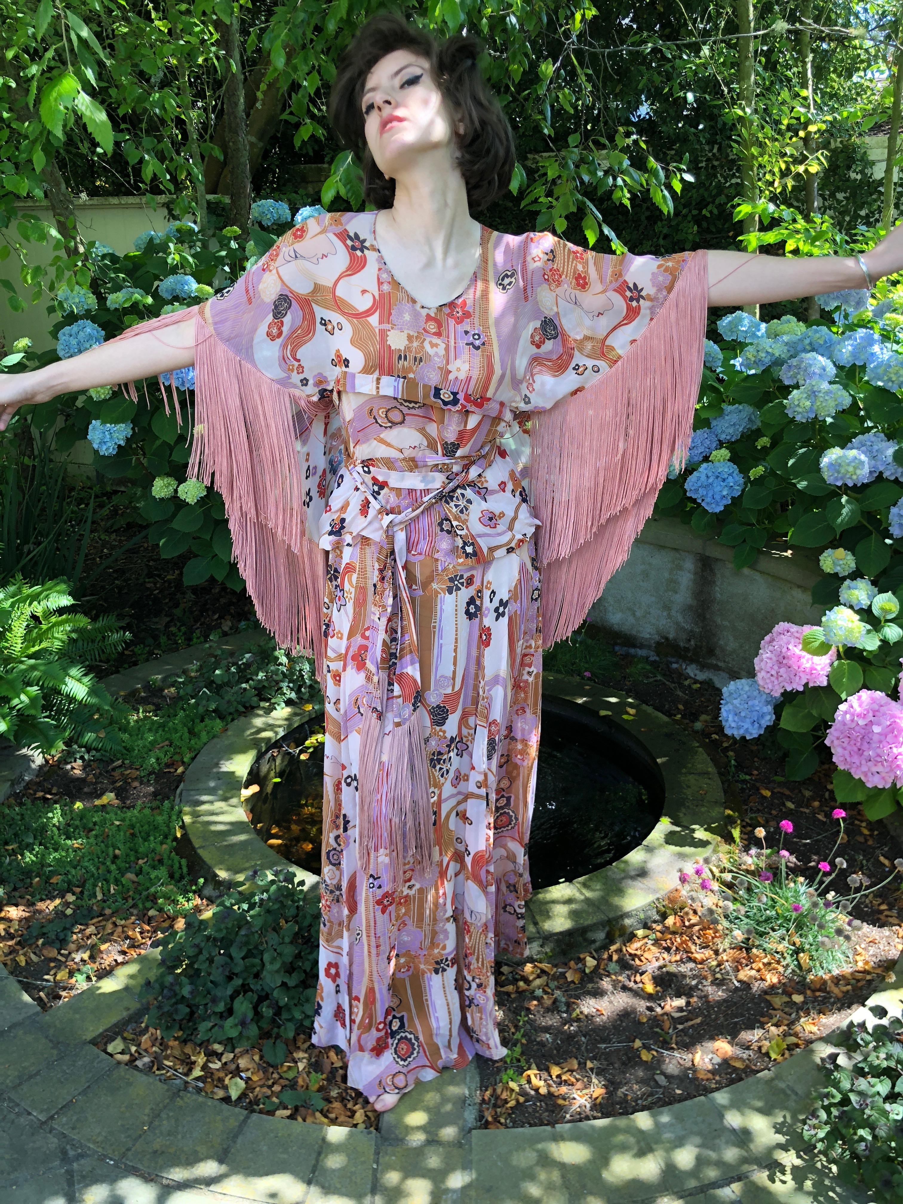 Cardinali 1970's  Ruffle Silk Hippie Print Fringed Evening Dress Ensemble.
Featuring a skirt and a wrap style top with fringe, so groovy.

From the Archive of Marilyn Lewis, the creator of Cardinali
Cardinali was founded in Los Angeles in 1970, by