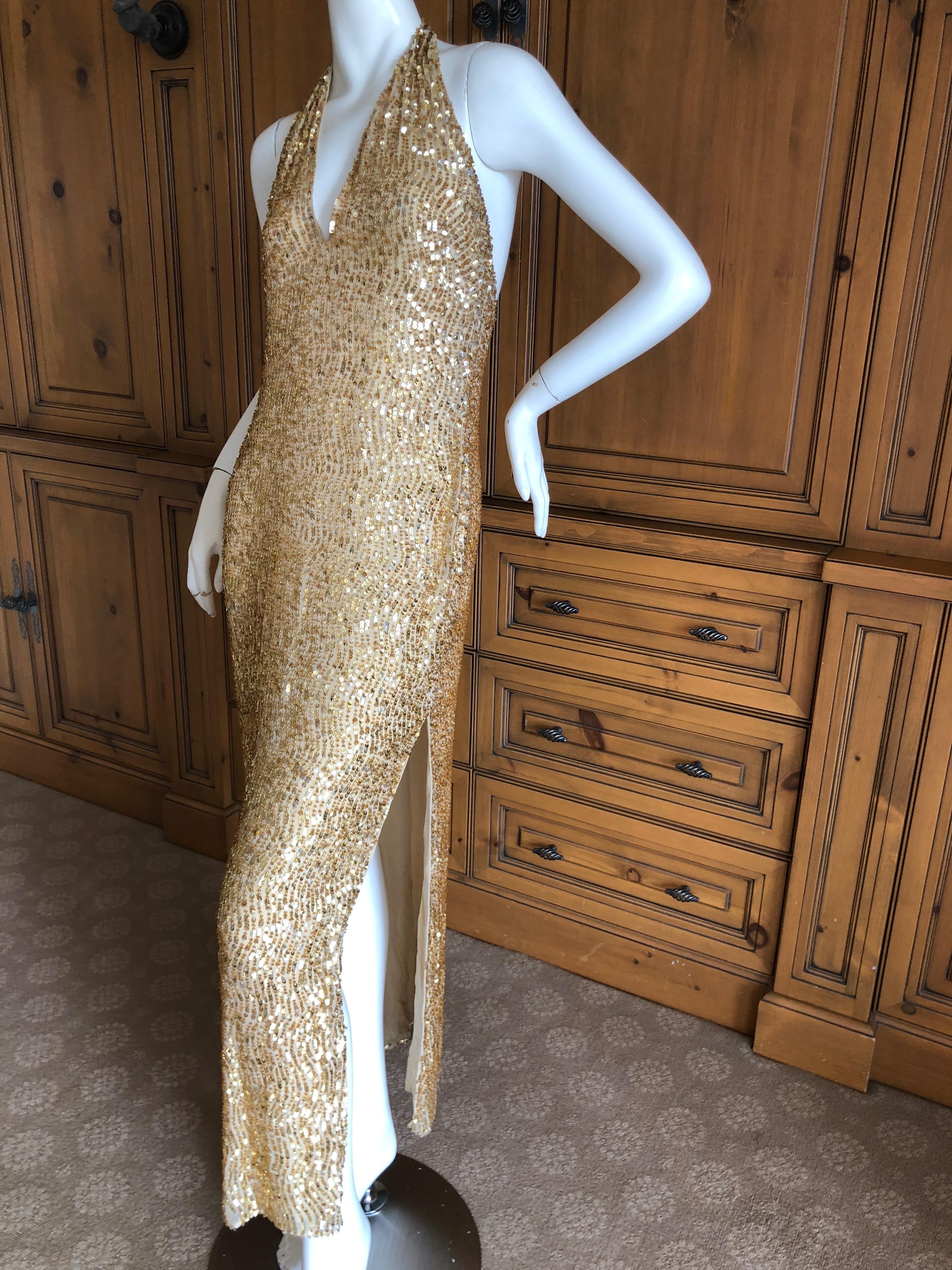 Halston by Randolph Duke 1999 Gold Sequin Halter Style Evening Gown.
This is so much prettier than the photos show, and needs to be seen in motion, preferably under the disco ball.
Featuring a halter neckline and a high slit, this is so