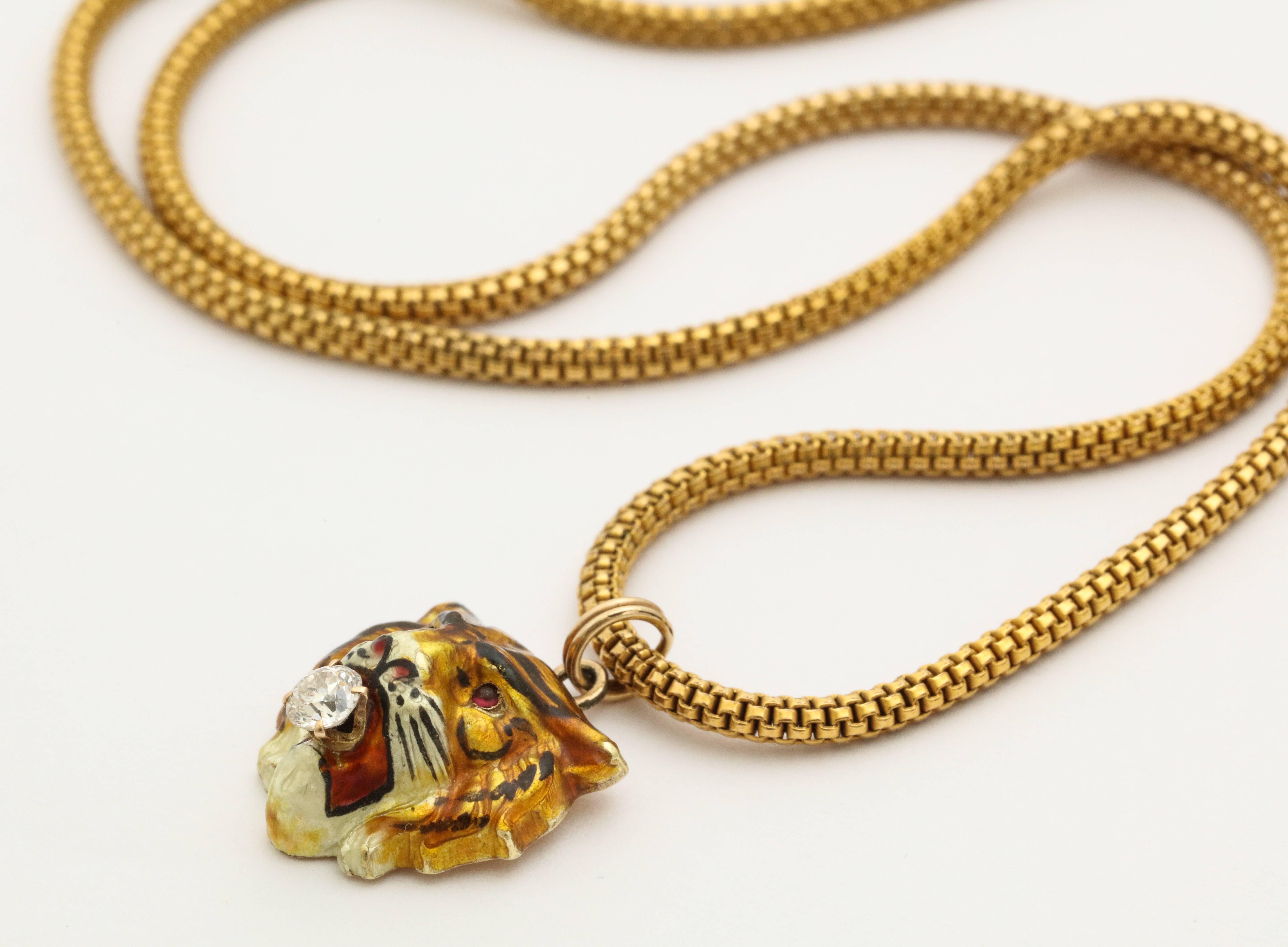 A detailed hand painted enamel tiger 18 kt gold pendant with ruby eyes and a diamond in its mouth on a 18 kt gold chain. Tiger head is 0.5