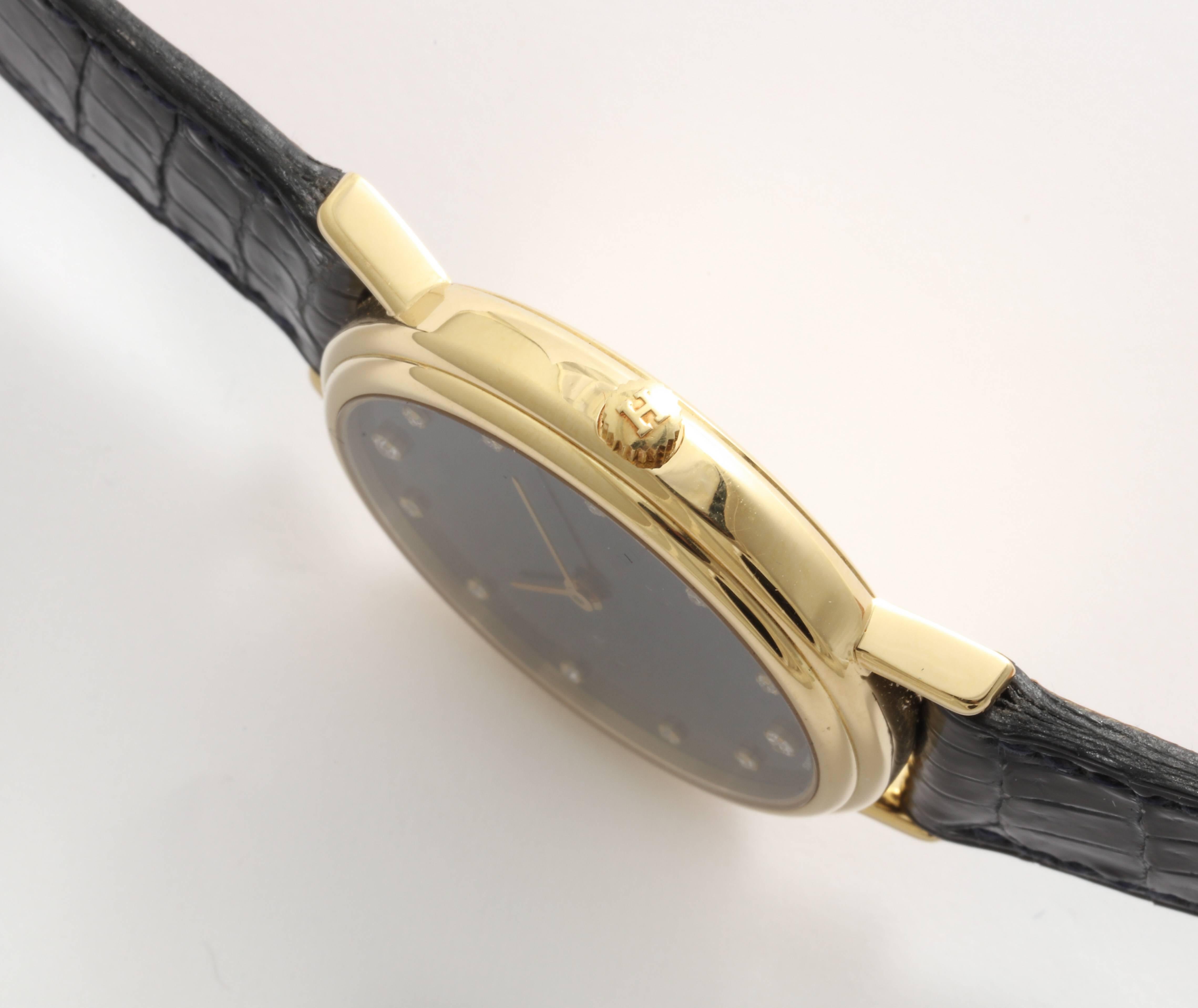 A fabulous Hermes wrist watch with diamond numerals on a slate color face and set in 18 kt Gold. This watch is rare and very desirable. it is the original strap in the original box