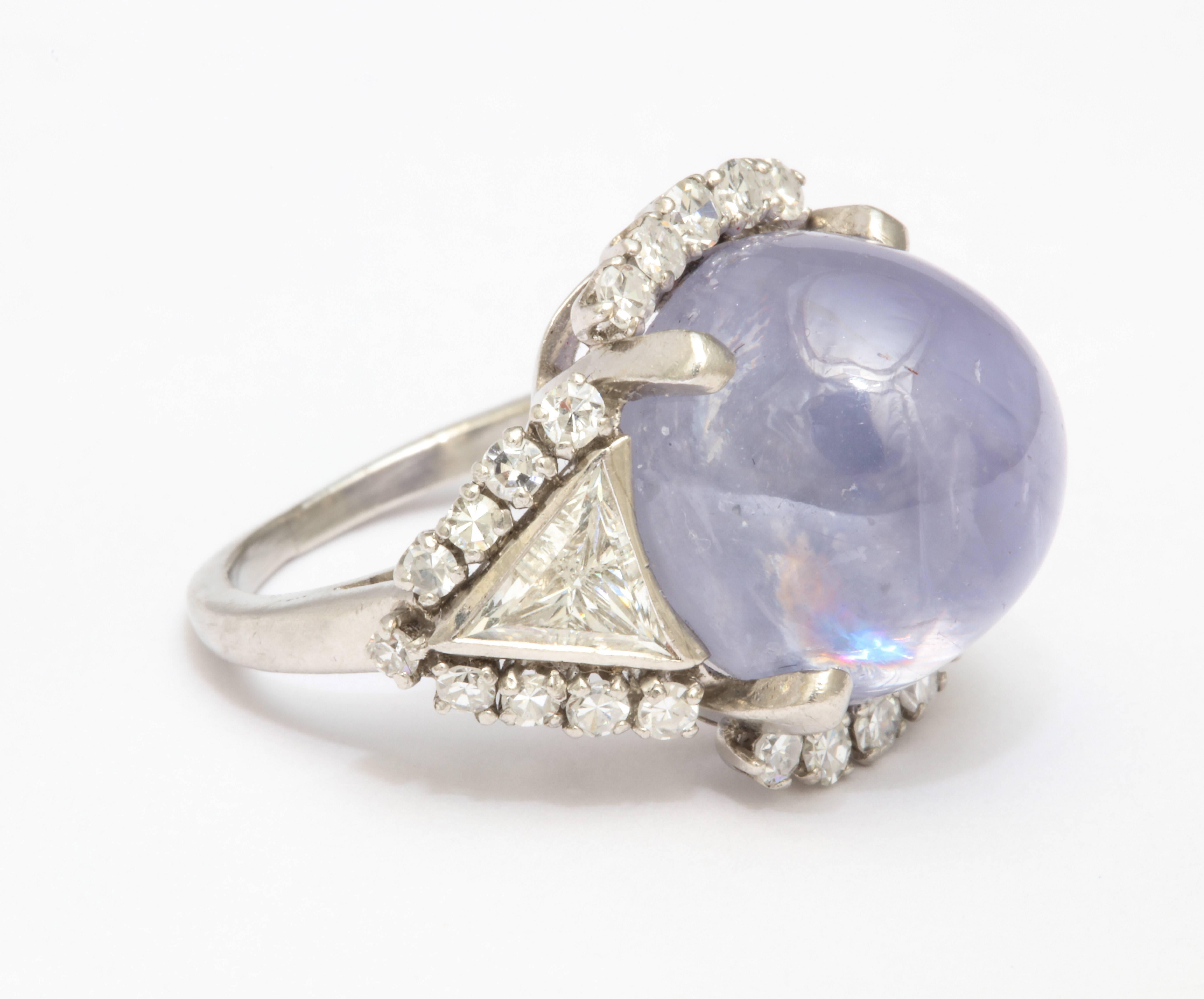  A stunning  lavendar Star Sapphire with with a triangular Diamond flanking each side as well as round diamonds encircling the star sapphire and triangle diamonds...beautiful mounting.  The ring is set in Platinum with AGI certificate 