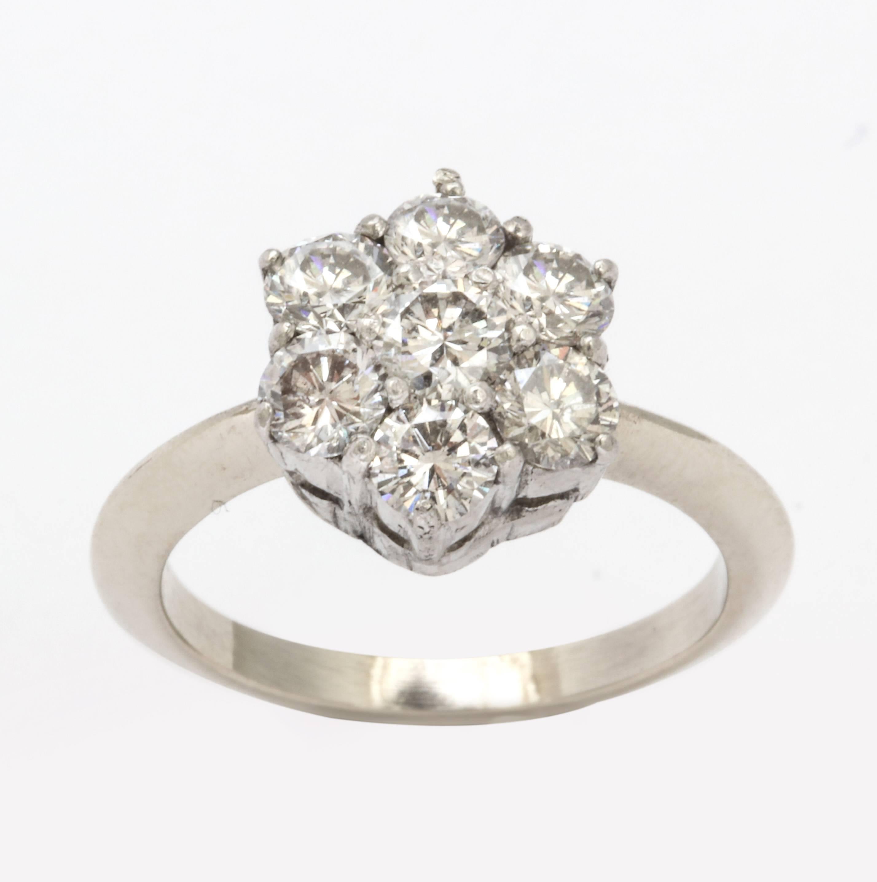 A wonderful re-fashioned ring in platinum and white gold with a grouping of brilliant cut diamonds in a floral arrangement.  This ring is the mate to a  ruby ring which was worn together and have 
been separated.