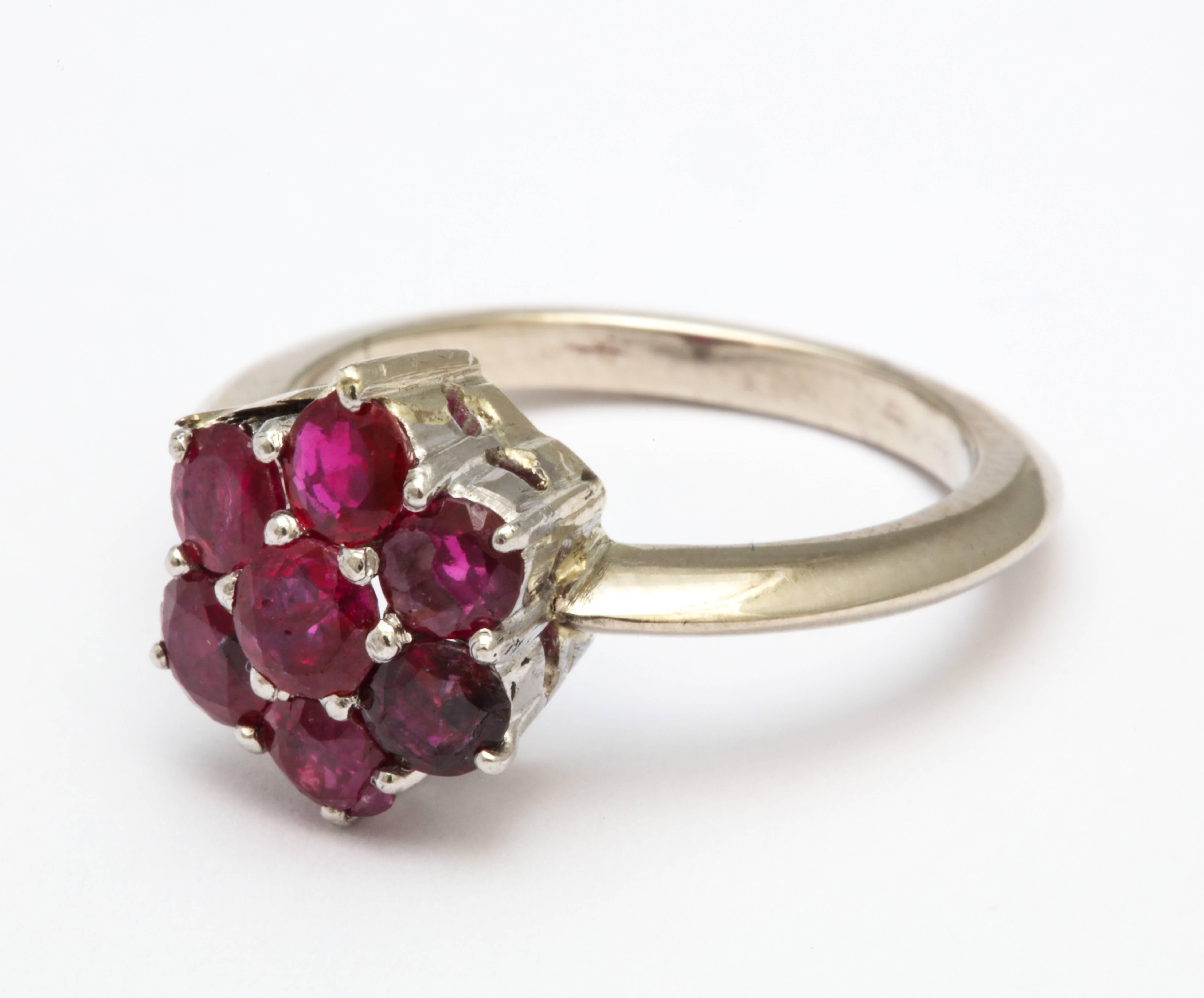 A wonderful re-fashioned ring in platinum and white gold  with a grouping of untreated natural rubies set in a floral arrangement. This ring has a matching diamond ring which was worn as one
and we have separated.