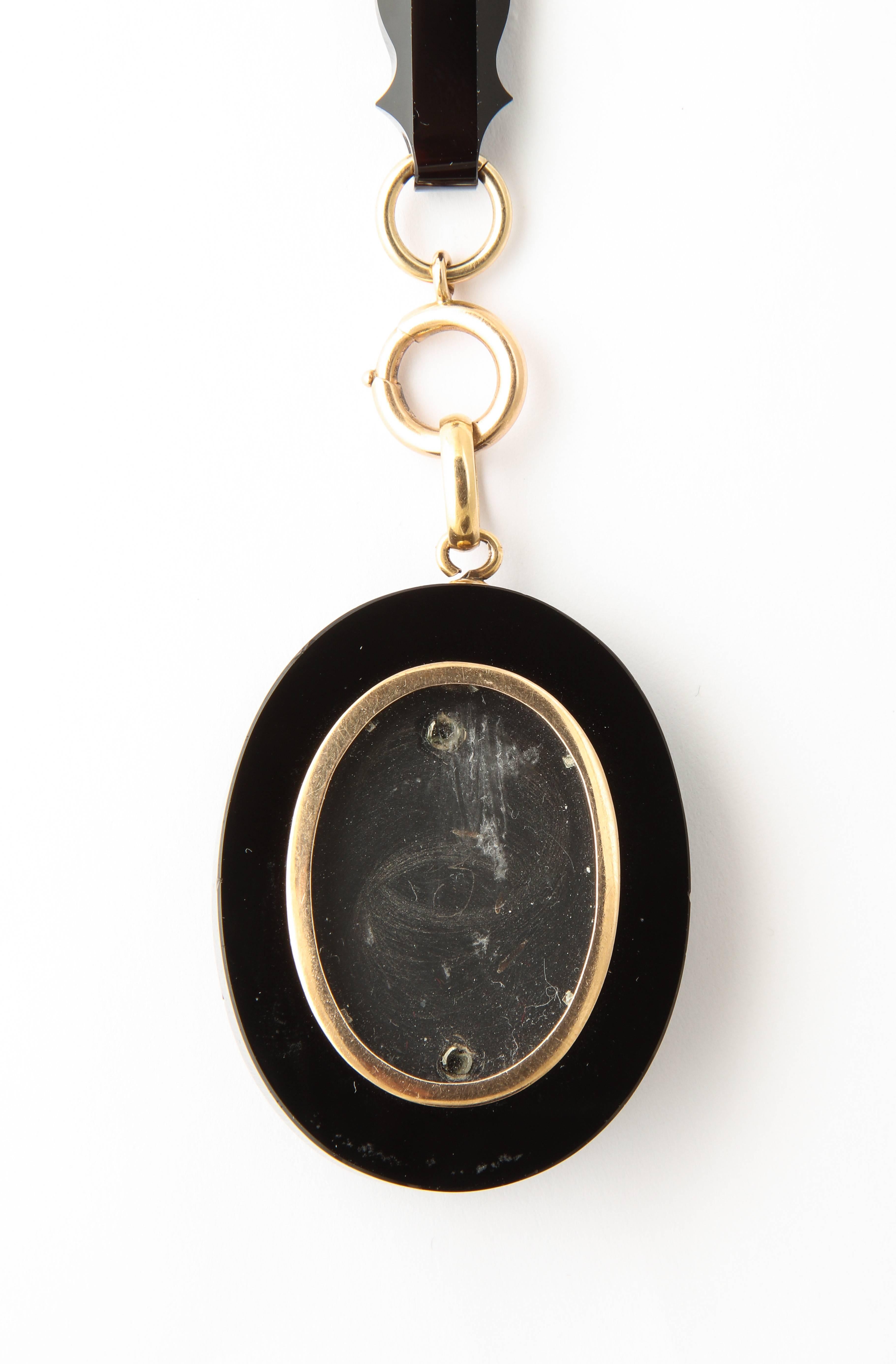 A wonderful period antique onyx and 18 kt chain and locket set from the late 1800s with a floral decoration in gold and seed pearls
