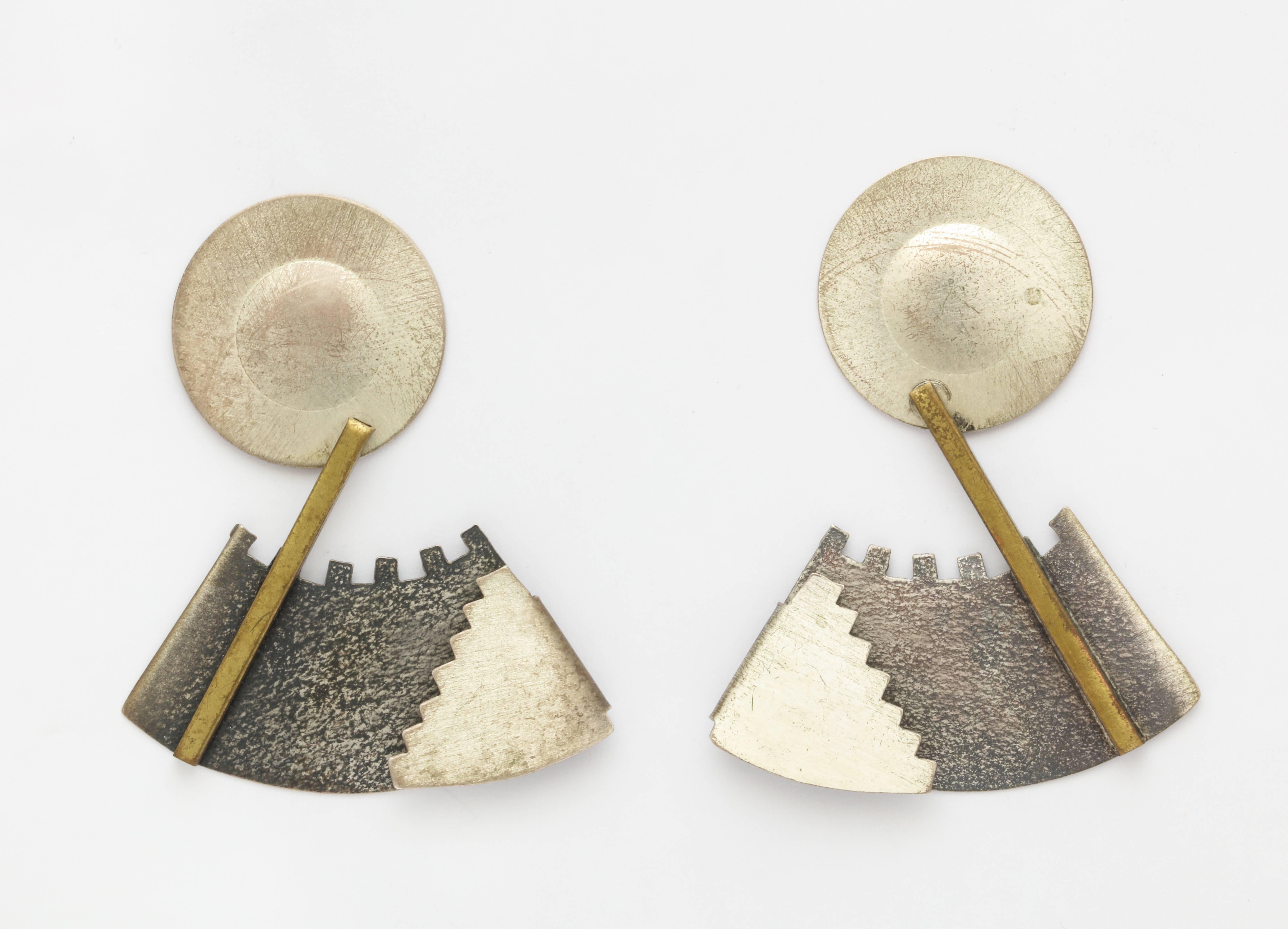 A wonderfully crafted pair of Memphis style earrings in silver and brass by an American Artisan with hand hammered areas and distressed finishes. Unsigned