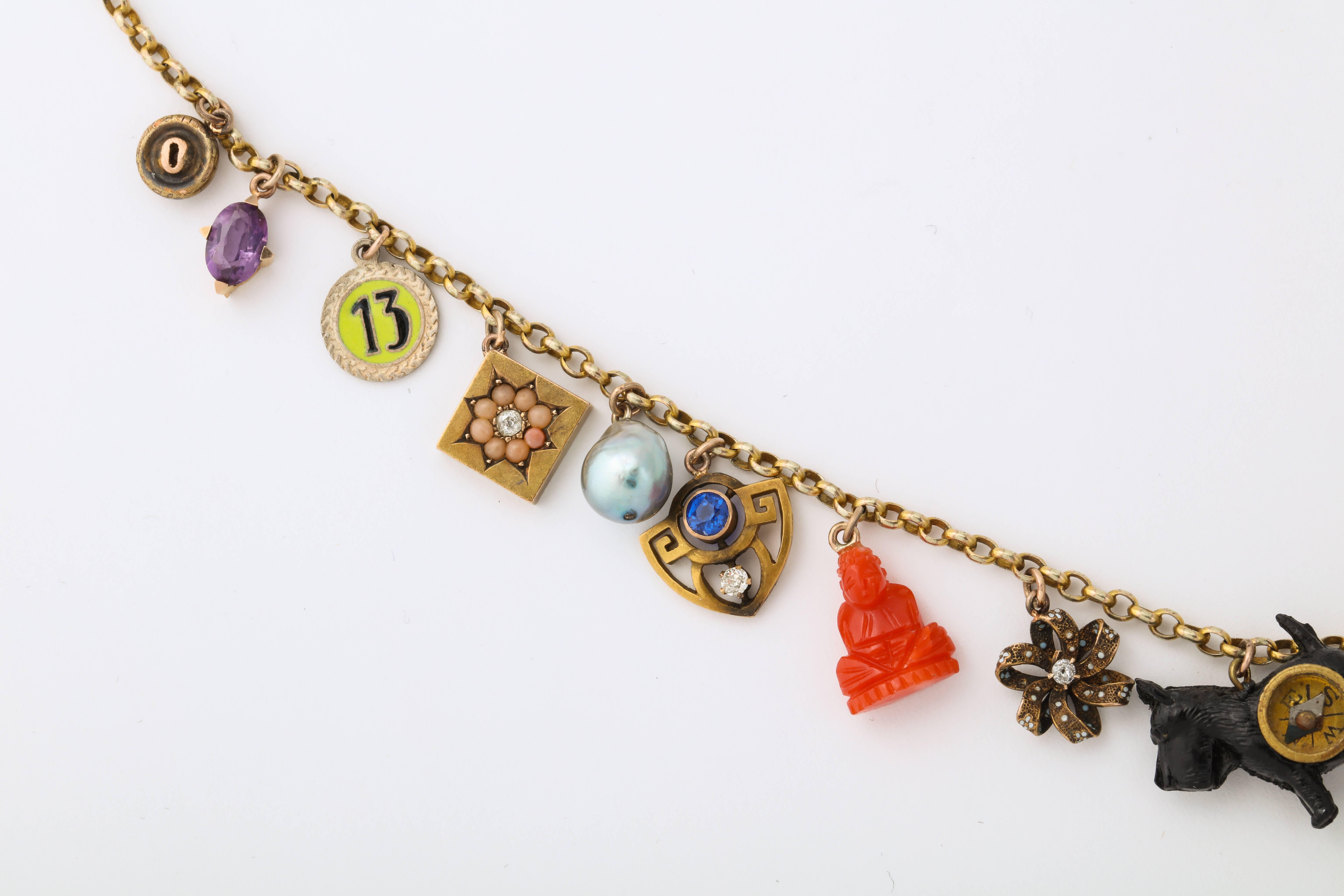 A wonderful pocca book charm necklace with 10 kt charms including diamond, amethyst, coral, sapphire, pearl, enamel, opal, garnet, and emerald designed by Katherine Wallach