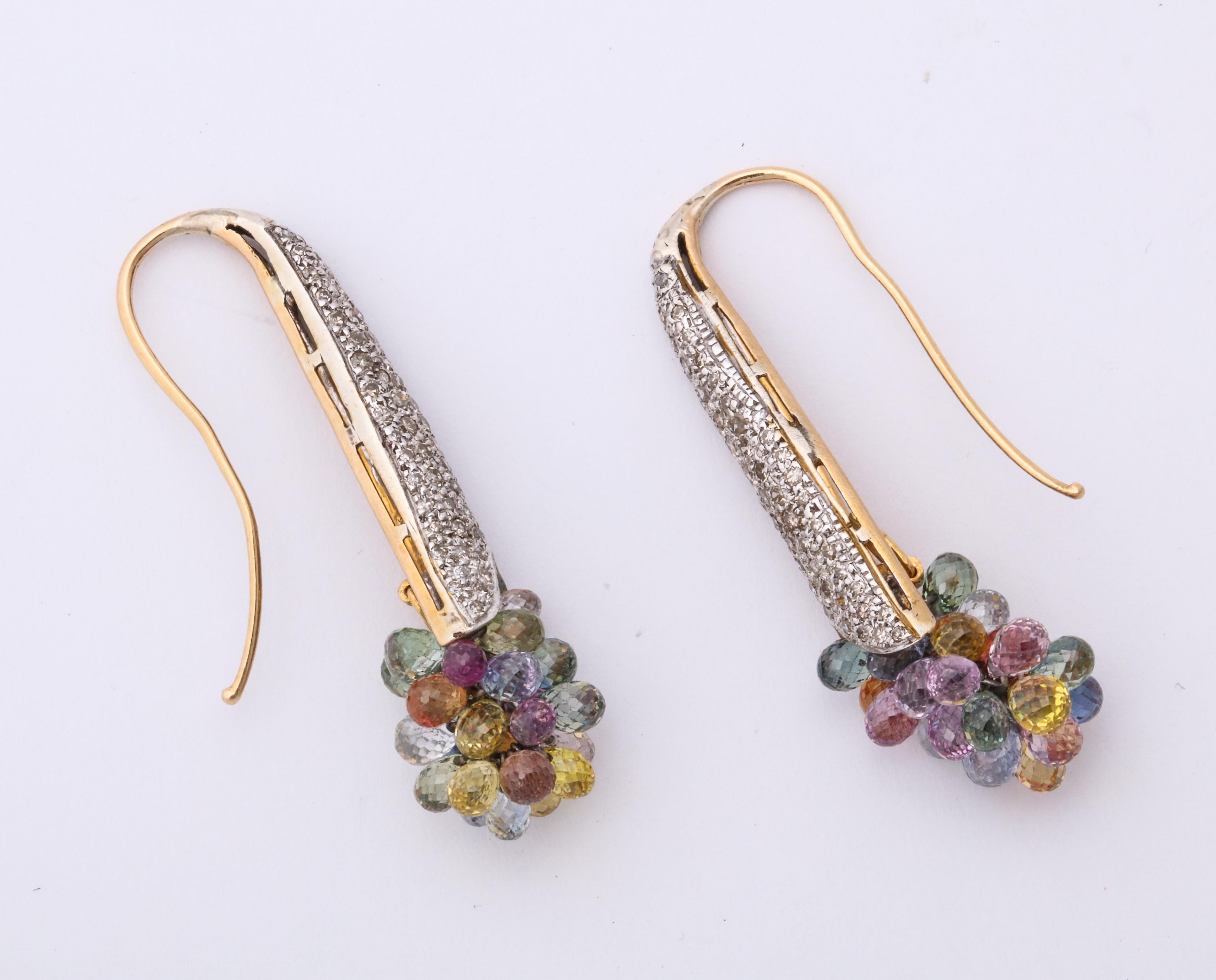 A charming pair of platinum and gold earrings with a  cluster of faceted dangling gemstones at the bottom. These are amazing earrings and can be worn with pleasure.