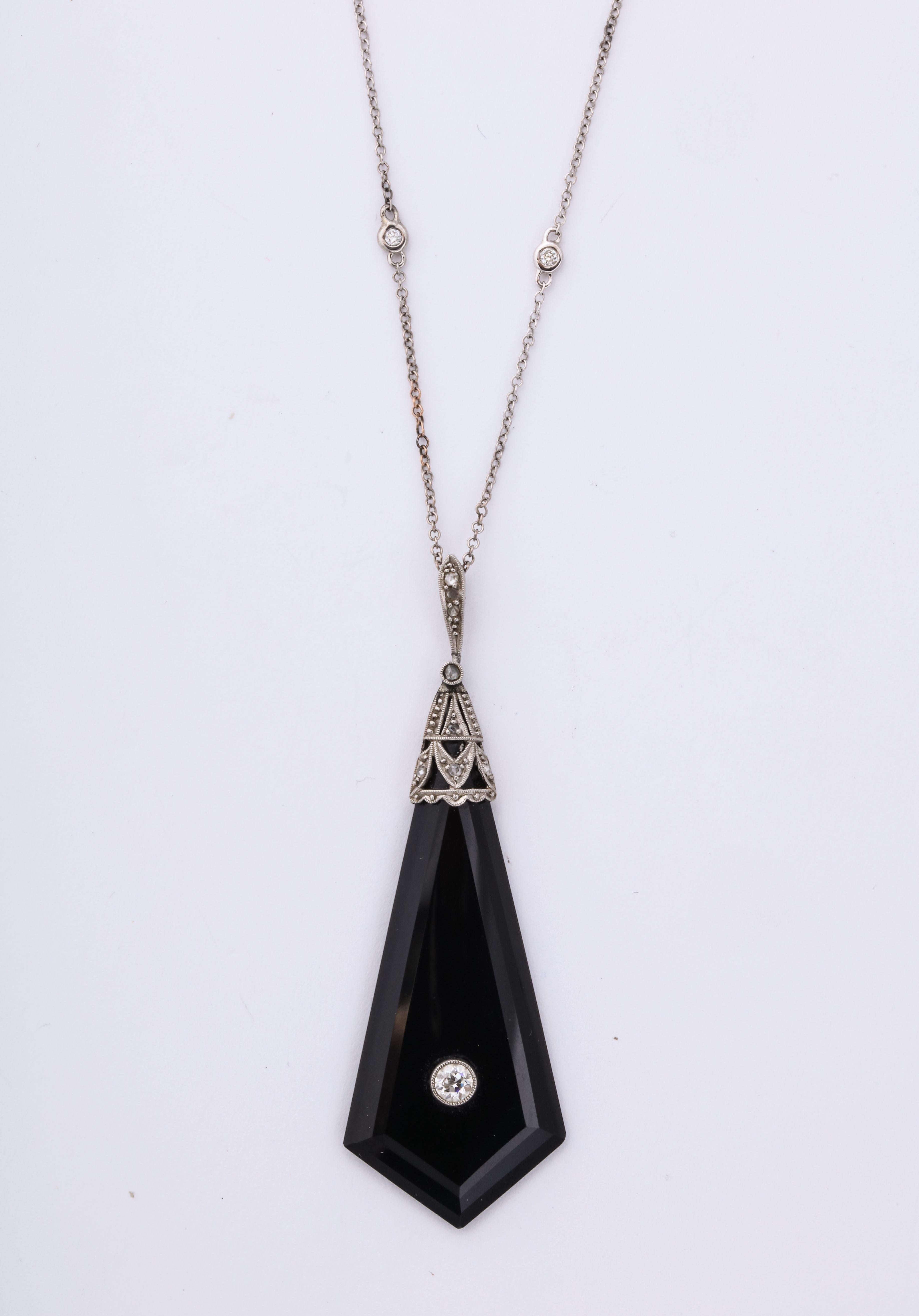 A great faceted onyx pendant with a diamond center. Diamonds are set along the white gold chain