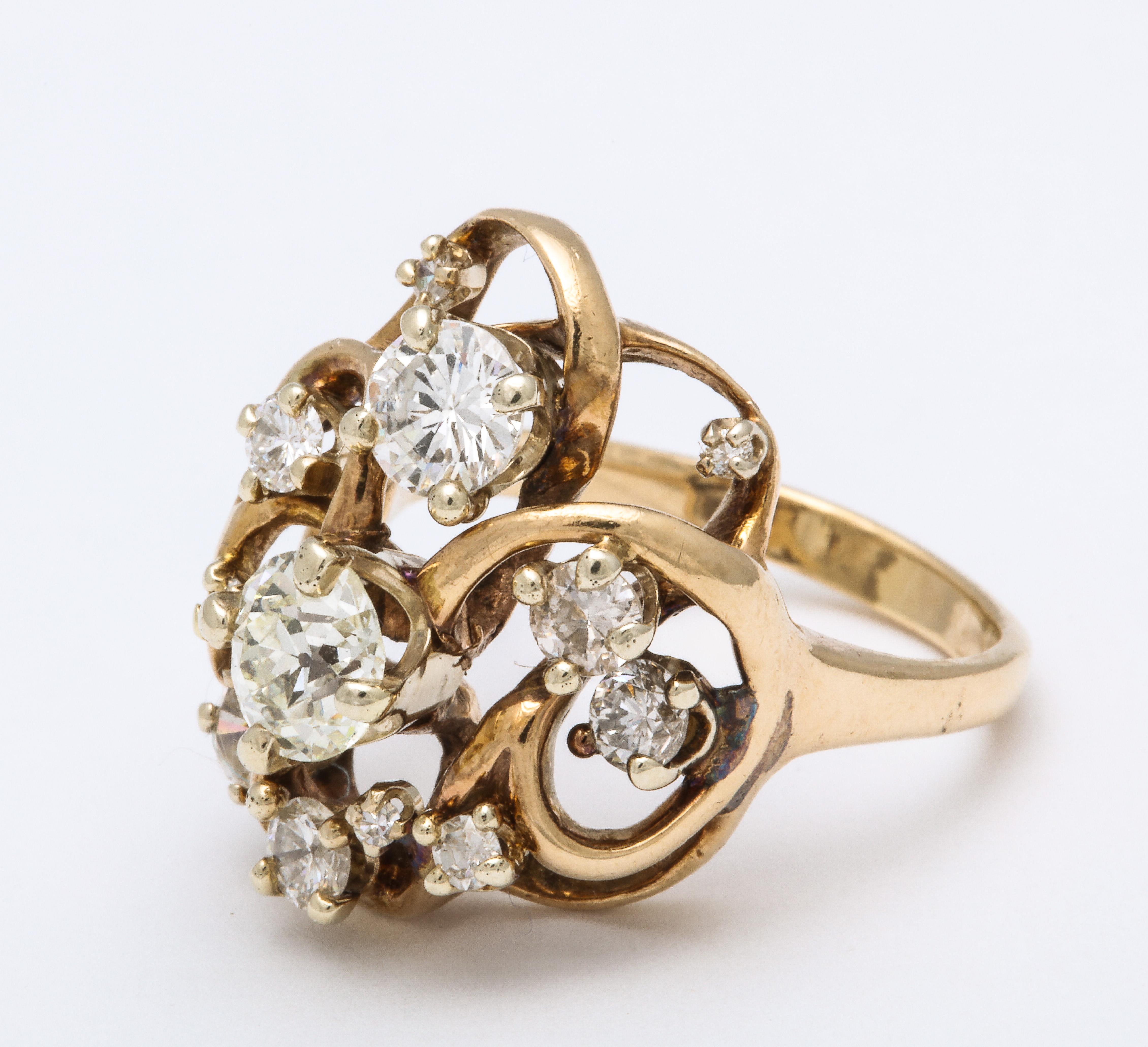 A wonderful cluster of mine-cut diamonds swirl around a center larger stone. Set in a gold open work mounting, this ,ring has a modern look but a vintage piece.