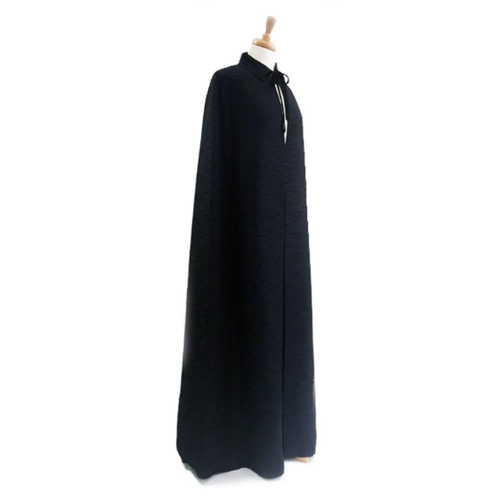 Severely chic 1960's square shouldered  evening cloak. Beautifully tailored with seams on the back shoulders that indicate the arm, this means that the cloak lines are even more slimming. The slit pockets are concealed within the front seams and the