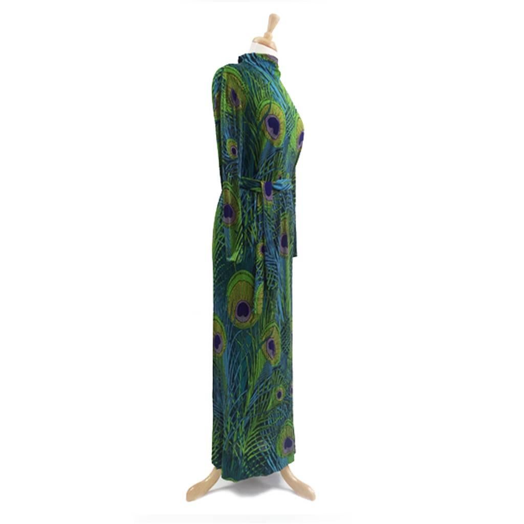 Exquisite Leonard Paris  Peacock Print Dress with tie belt. Clever construction inserts darts at bust but seam finishes at side hipline. Back seam to floor. Funnel neck with covered buttons down back, loop closures.Deep hem gives possibility of