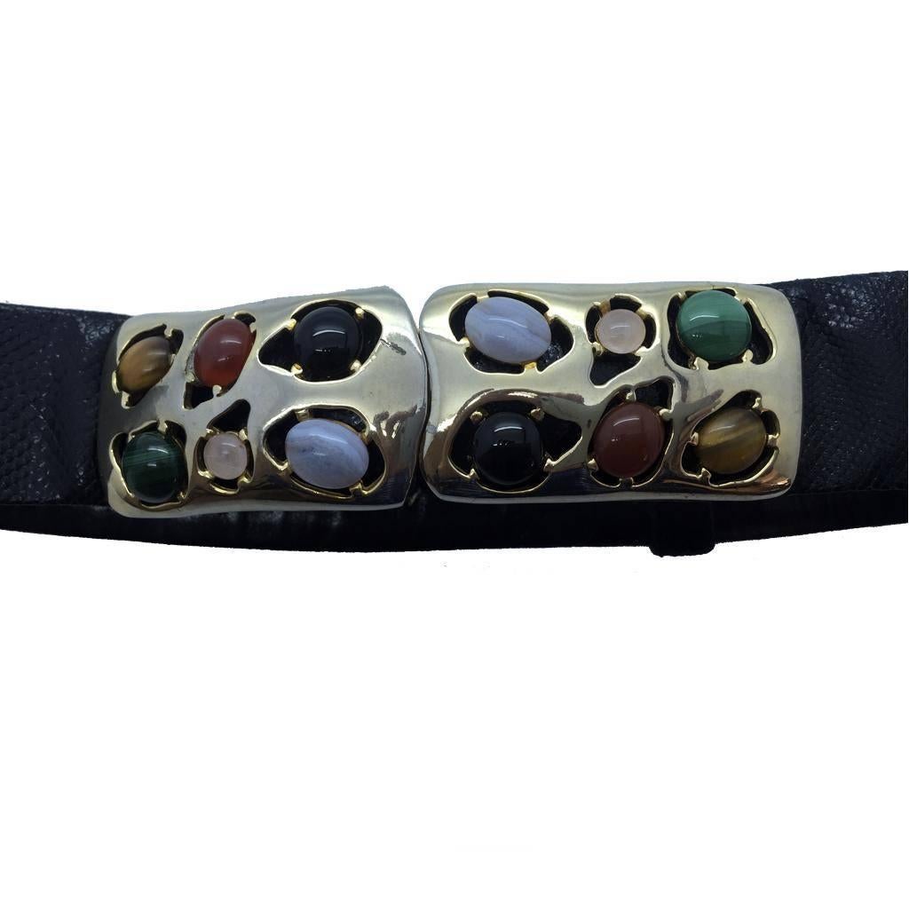 Statement Belt with gilded brass buckle set with semi precious stones, including Tiger’s Eye, Quartz, Cornelian, White Agate, Onyx and Malachite.Shaped Lizard skin belt is adjustable and lined in fine black calf skin leather.

Judith Leiber is an