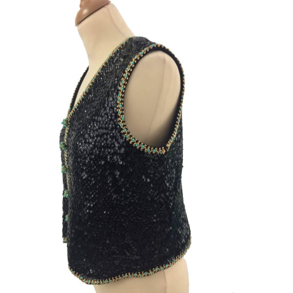 This is a fabulous example of 1960s Hong Kong made British glamour wear.
Update it over a white silk shirt!
Black sequins are trimmed with gold braid embroidered with faceted turquoise beads, the trompe l’oeil, single breasted traditional pointed