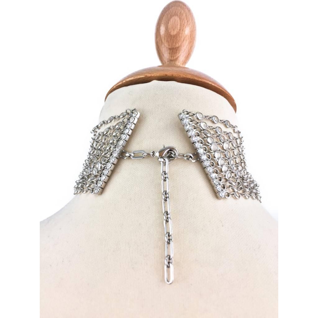This glamorous choker has 4 blocks of 12 strands of octagonal Swarovski crystals set in silver coloured metal chain, each block is separated by a solid bar with prong set diamanté.

Lovely worn over high collar shirt with no sleeves

Signed Butler